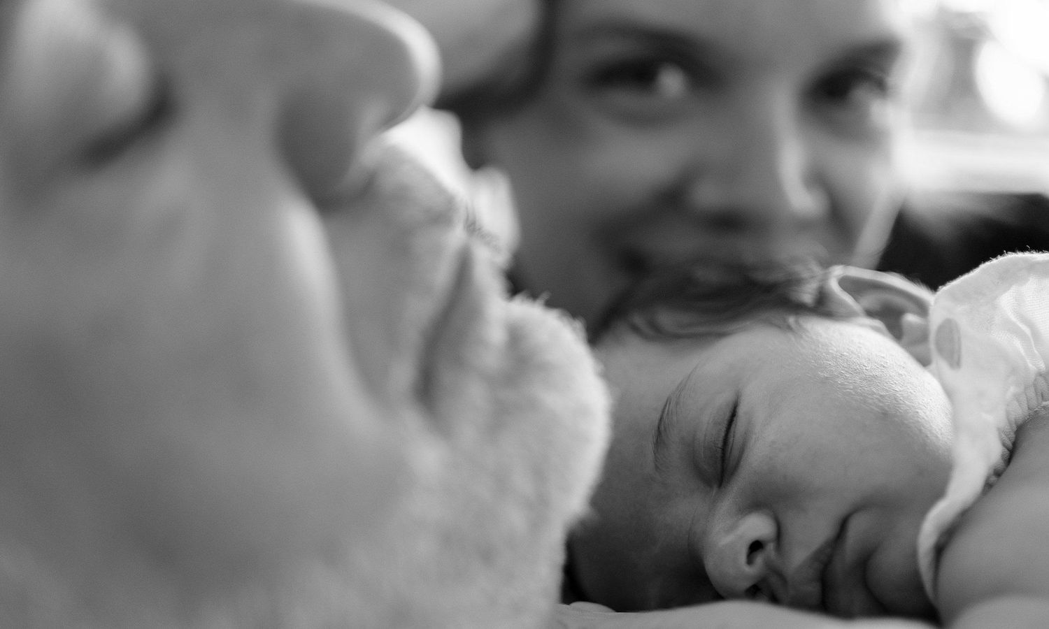 Black and white intimate portraits showing tender moments between couple. Photography by Raymond Mather.