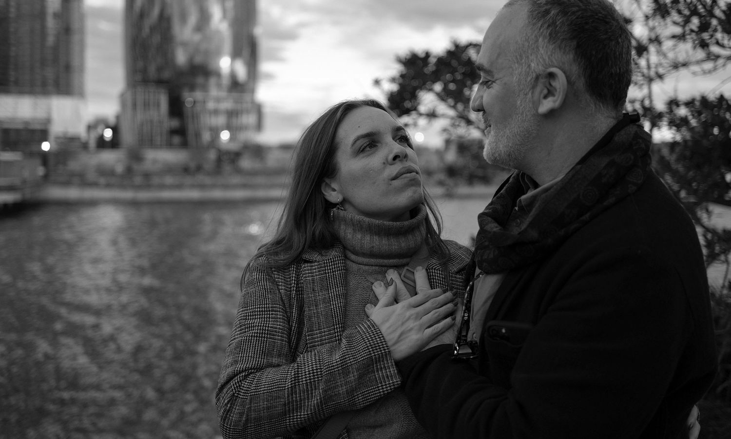 A series of black and white photographs showing intimate moments between two people in an outdoor setting.