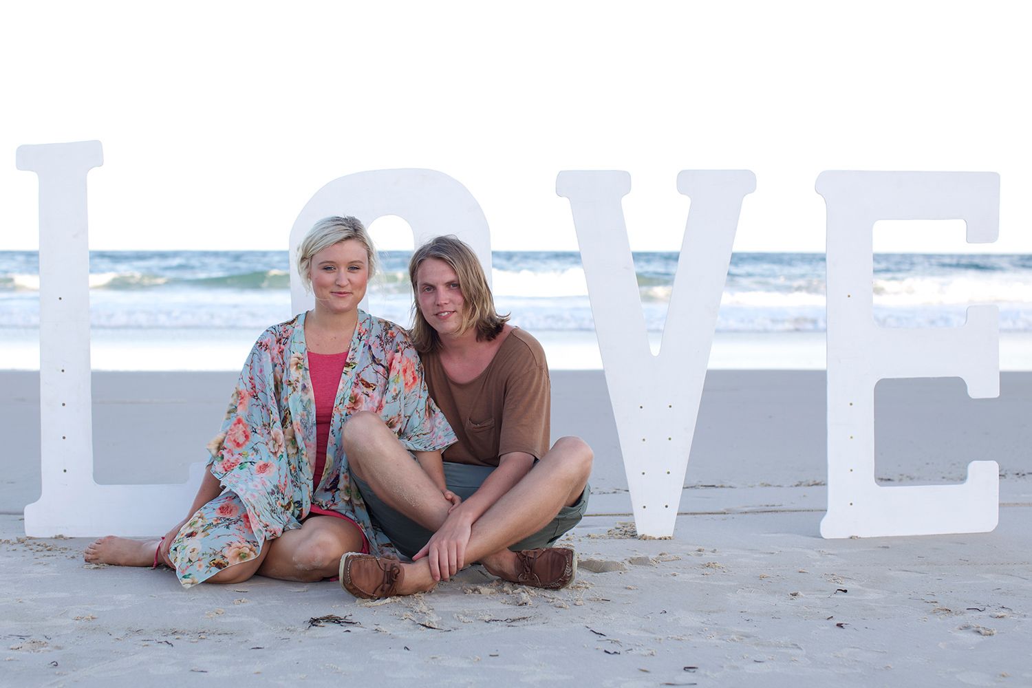 Beachside love story framed in white, calm, joy, and devotion. Photo by Raymond Mather.