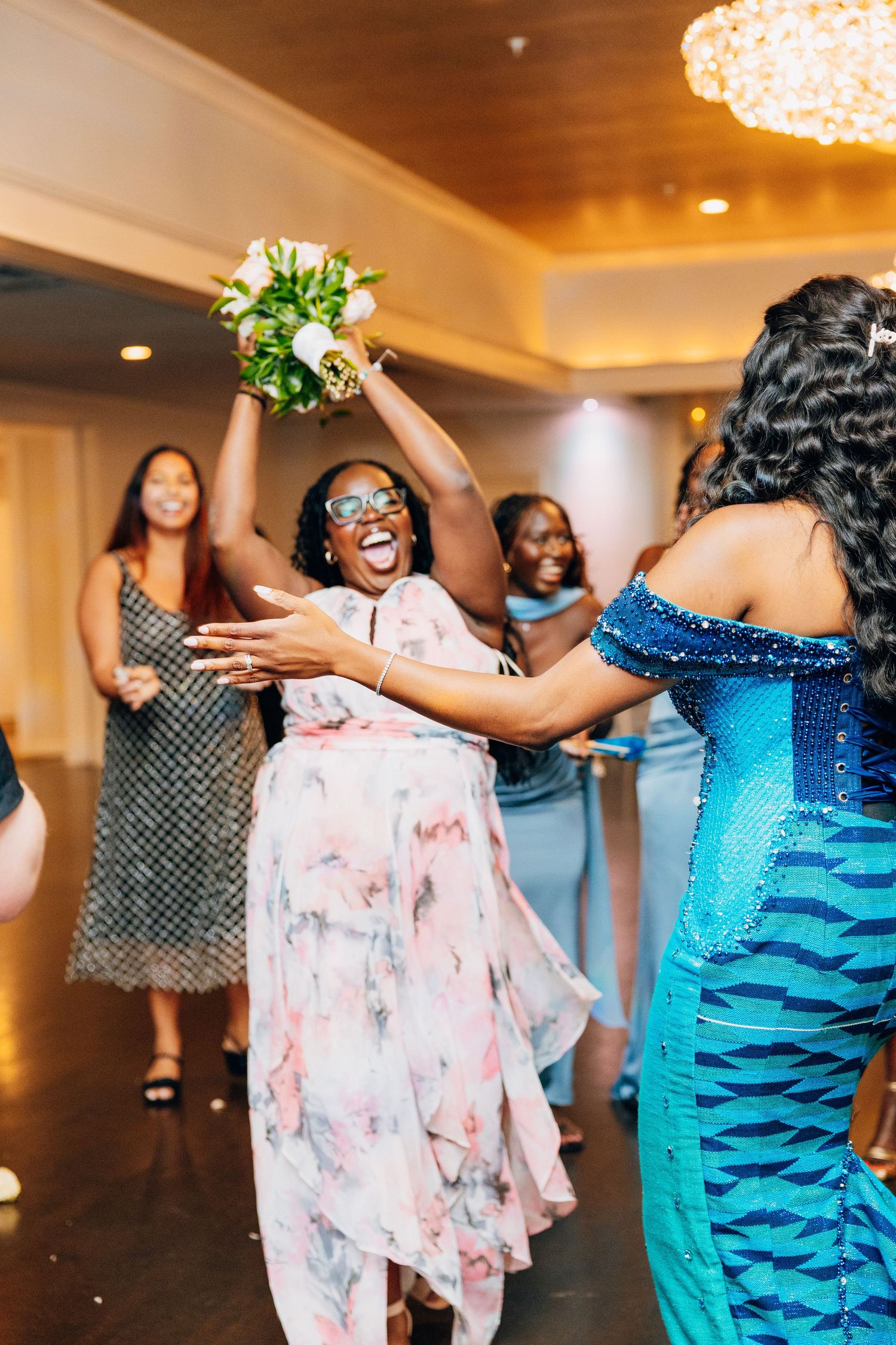 Excited guest catches bridal bouquet toss at wedding reception celebration.