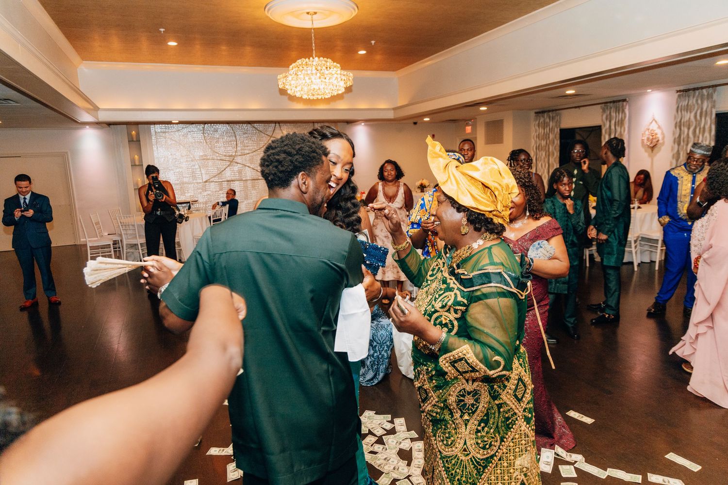 Guests celebrating and dancing at a vibrant African wedding reception with colorful traditional attire.