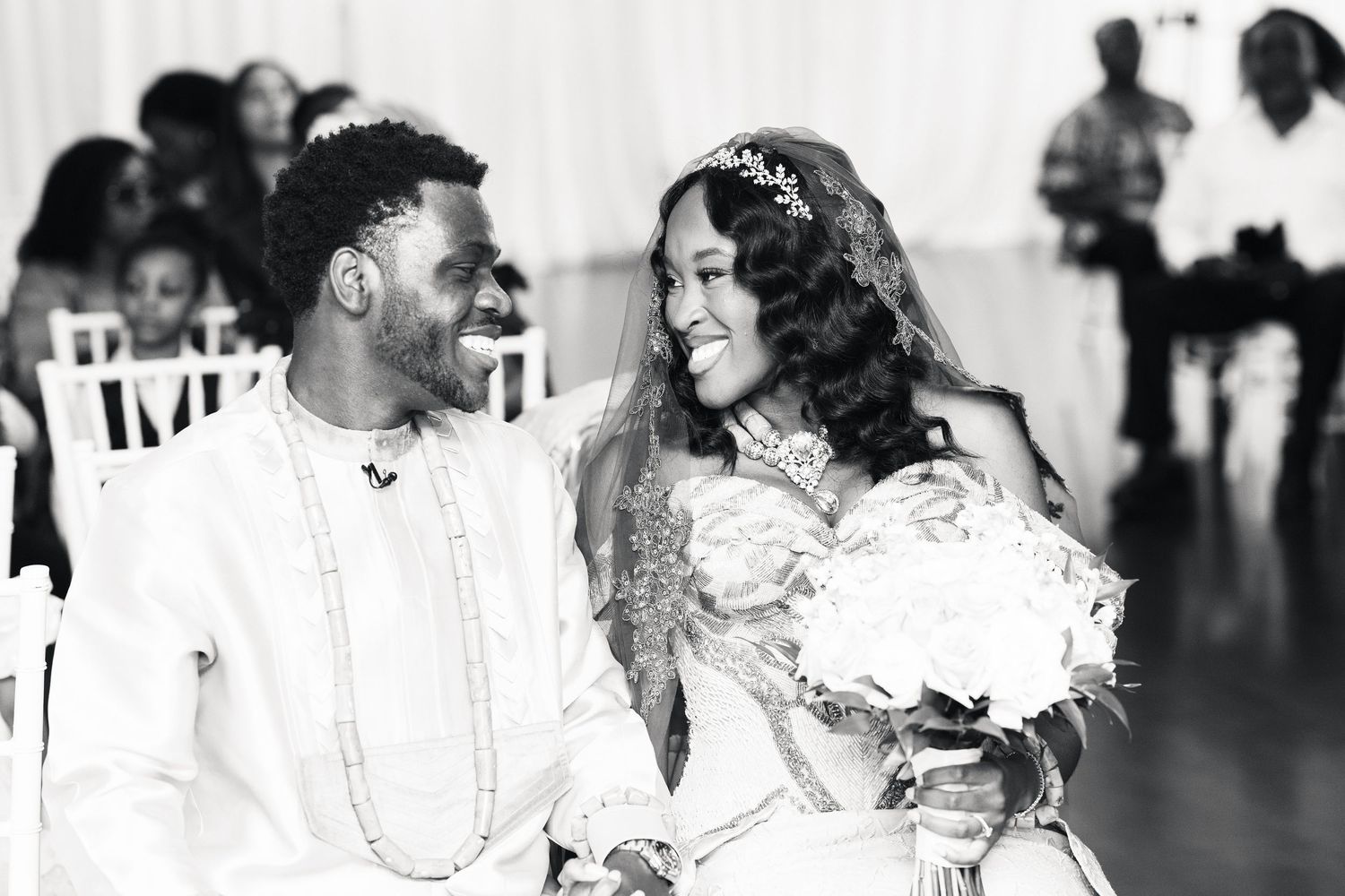Black and white portrait of smiling bride and groom sharing joyful moment at wedding.