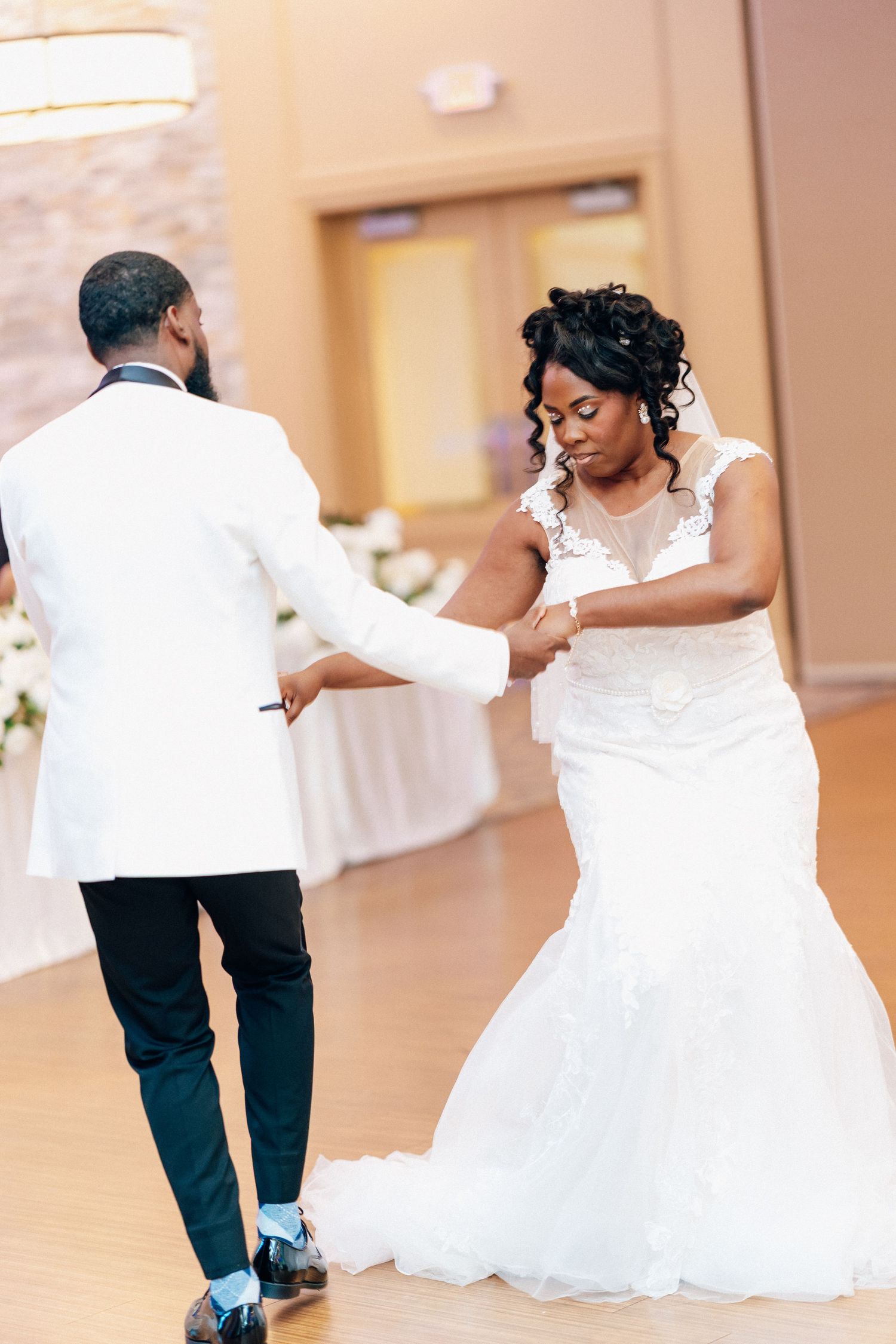 Bride and groom share their first dance, with the bride in a white mermaid gown at their wedding reception.