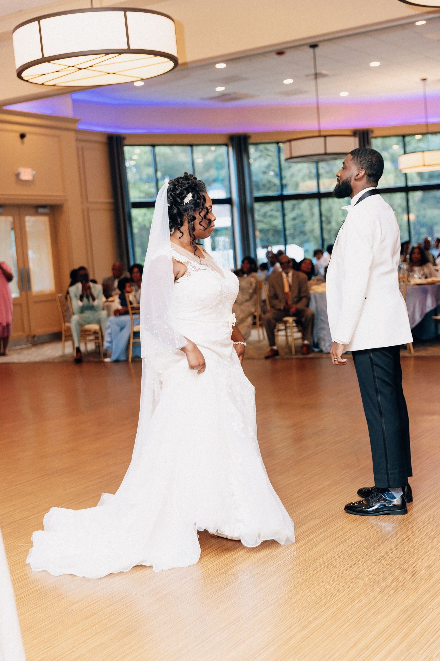 Bride and groom share their first dance in an elegant ballroom during their wedding reception.
