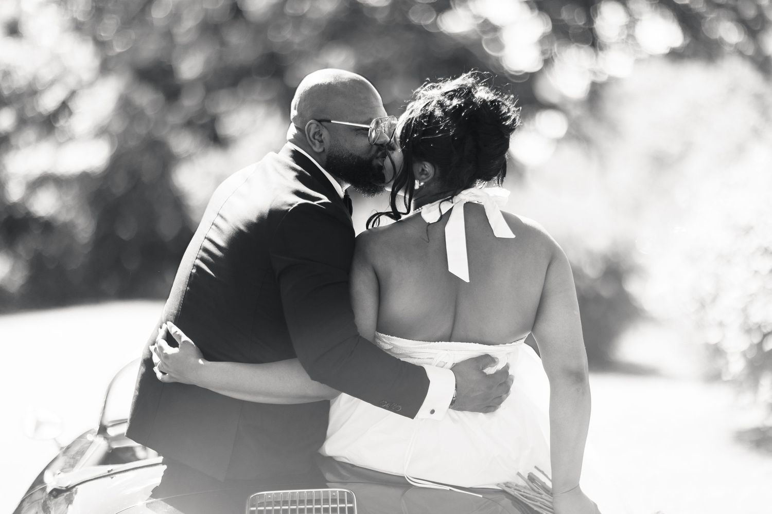 Black and white photo of groom tenderly kissing bride on the cheek at their wedding.