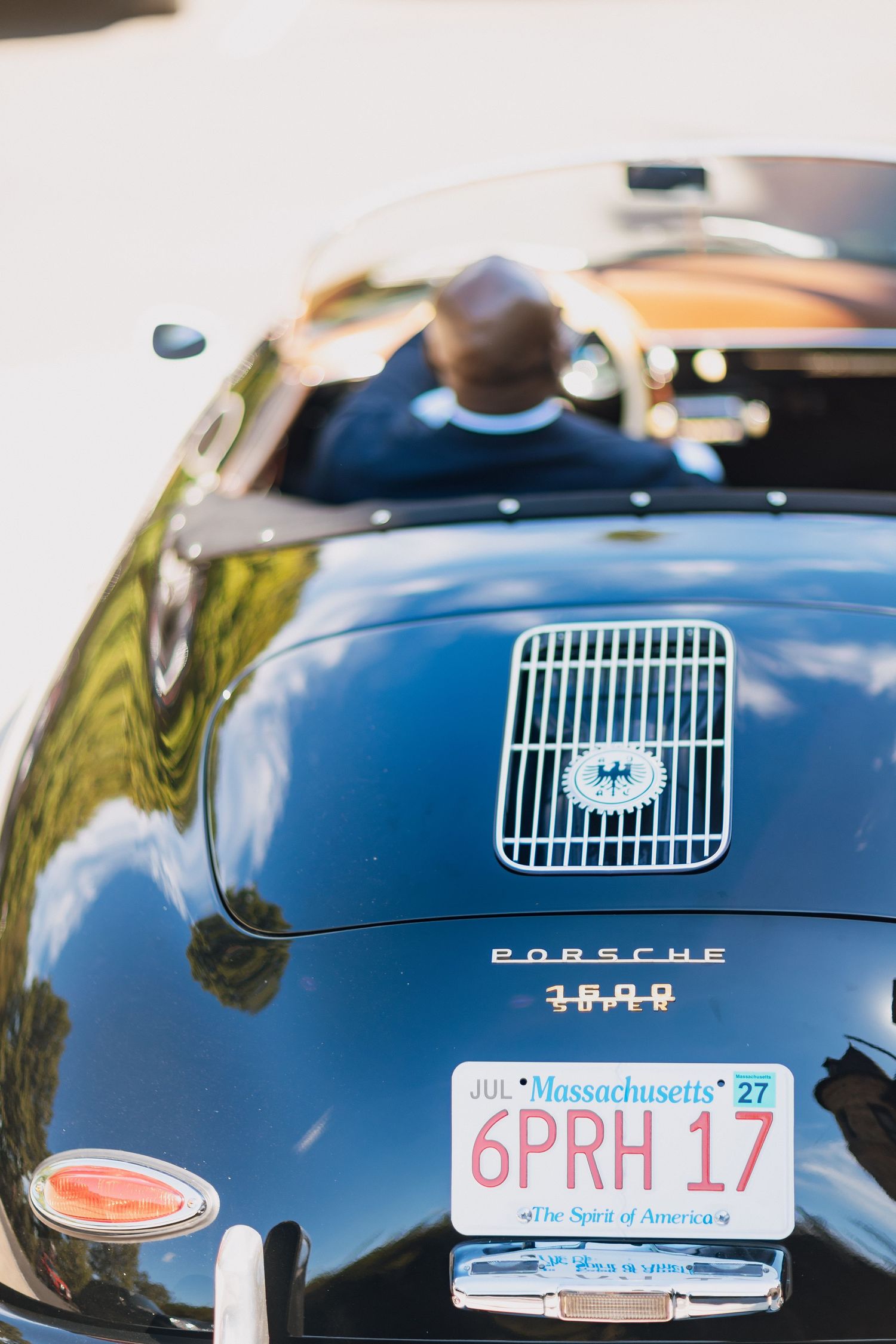 Rear view of a classic black Porsche 1600 with Massachusetts license plate 6PRH17 at a wedding.