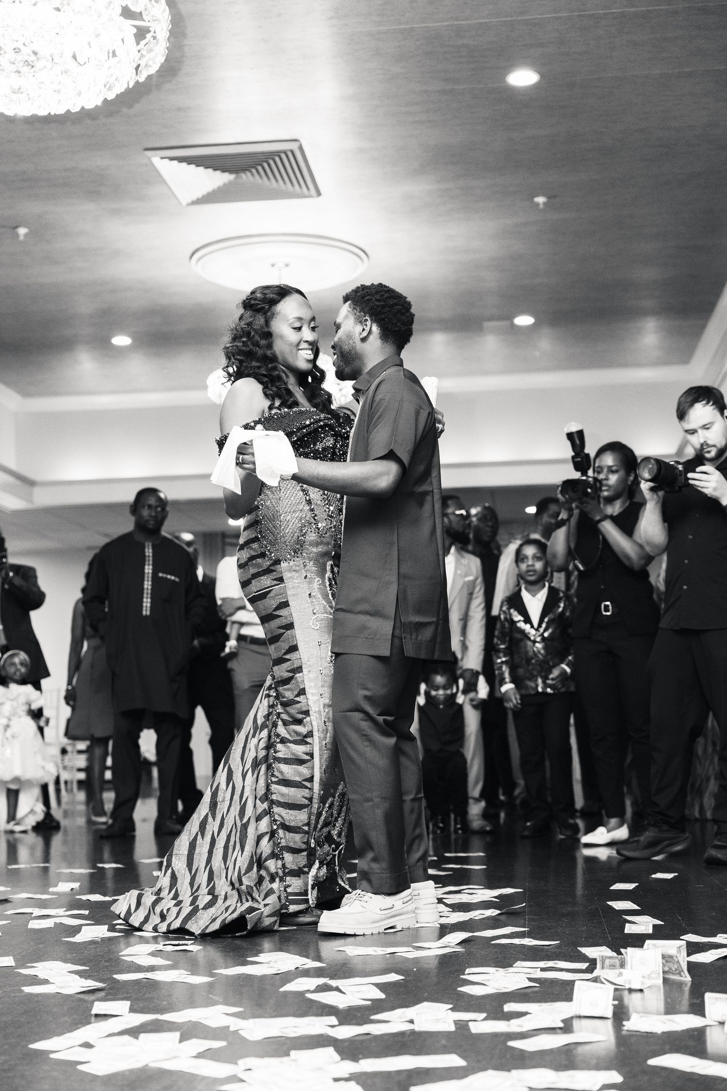 Black and white photo of couple sharing first dance at wedding reception.