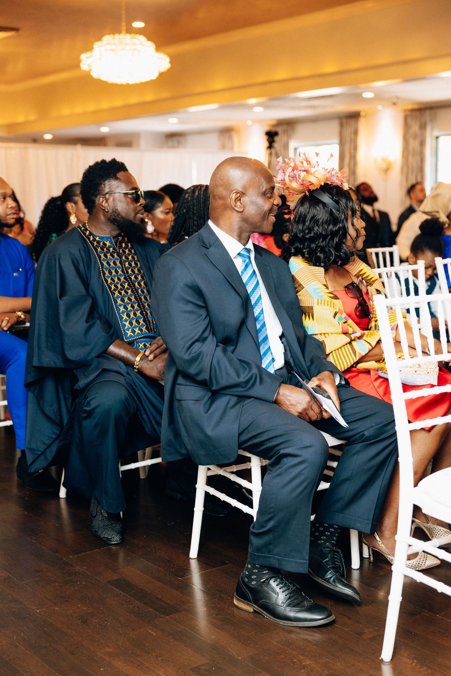 Guests seated at an African wedding ceremony in a decorated venue.