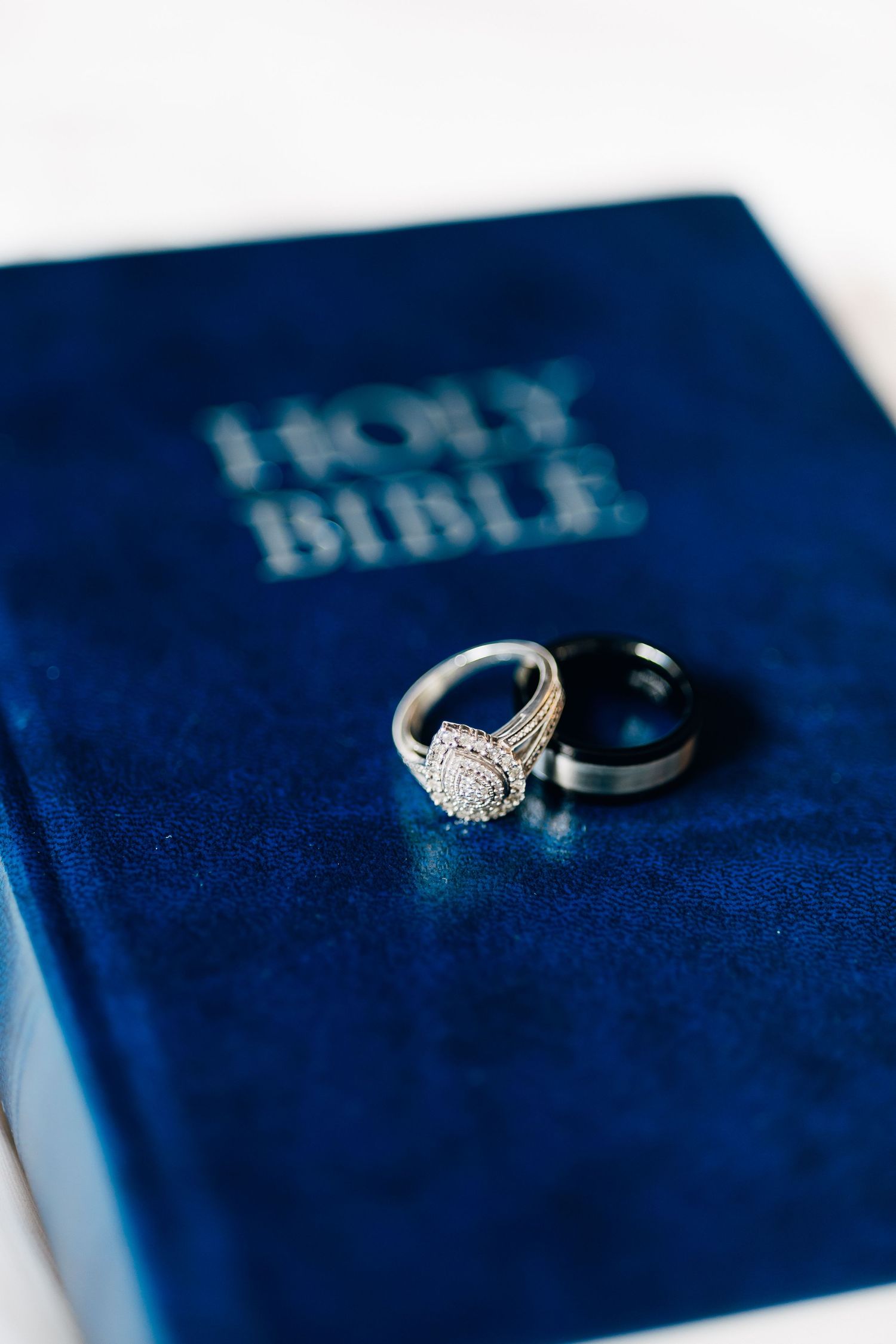 Wedding rings resting on a blue velvet Holy Bible, symbolizing faith and commitment in marriage.
