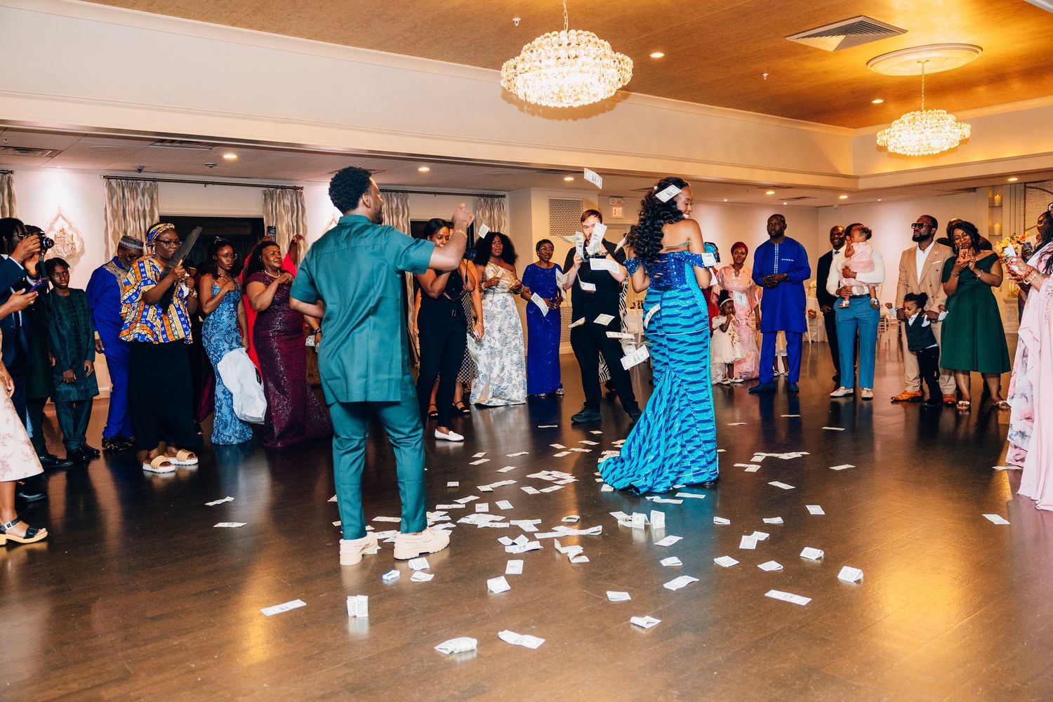 Lively wedding reception dance floor with guests celebrating and money being sprayed on the couple.