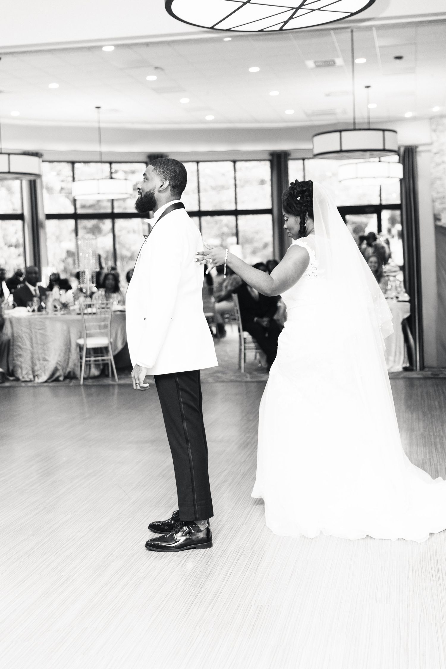 Black and white photo of bride and groom sharing intimate first dance at wedding reception.