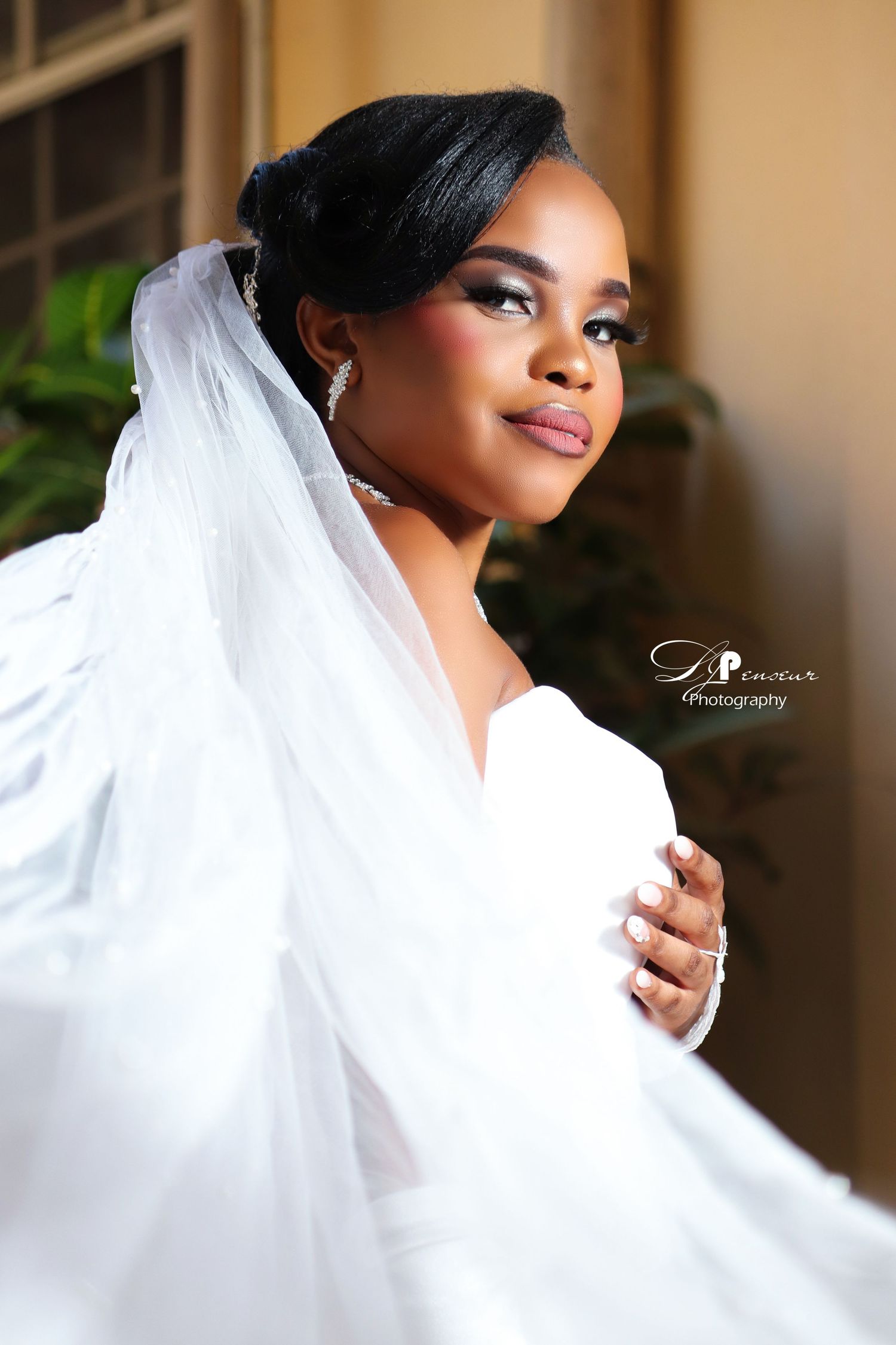 Soft focus bridal portrait captures dreamy side profile with flowing white veil.