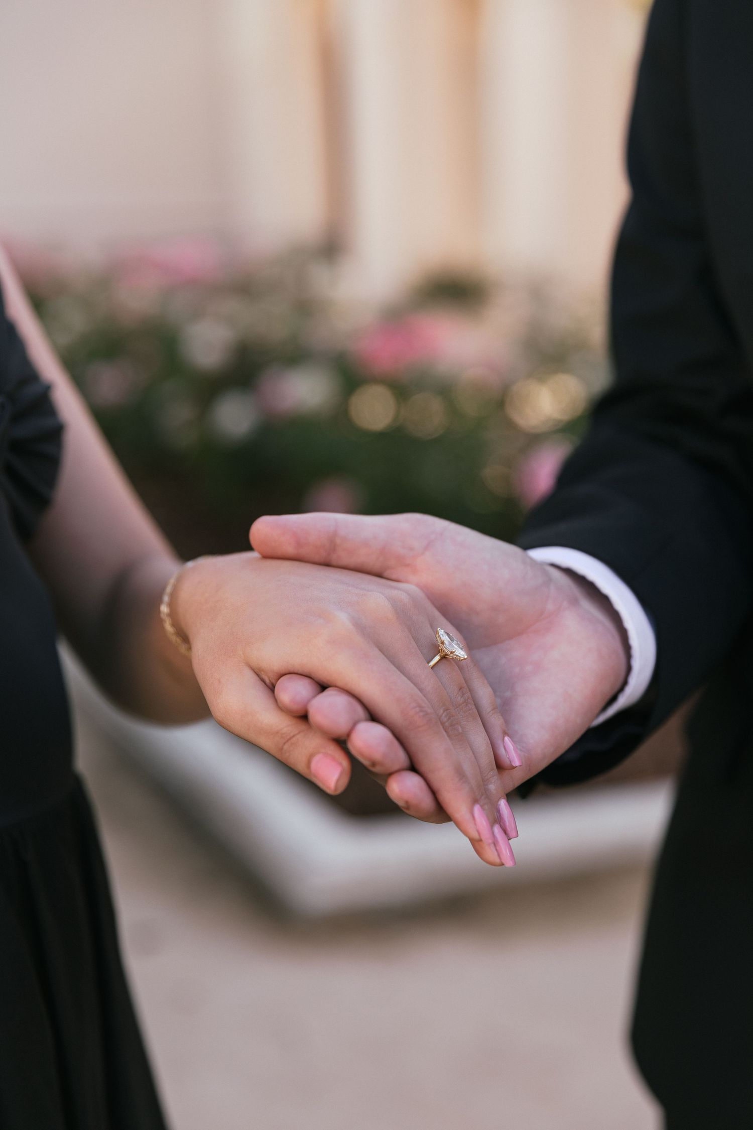 Close-up shots of hands and engagement ring against a garden backdrop at a historic mission.