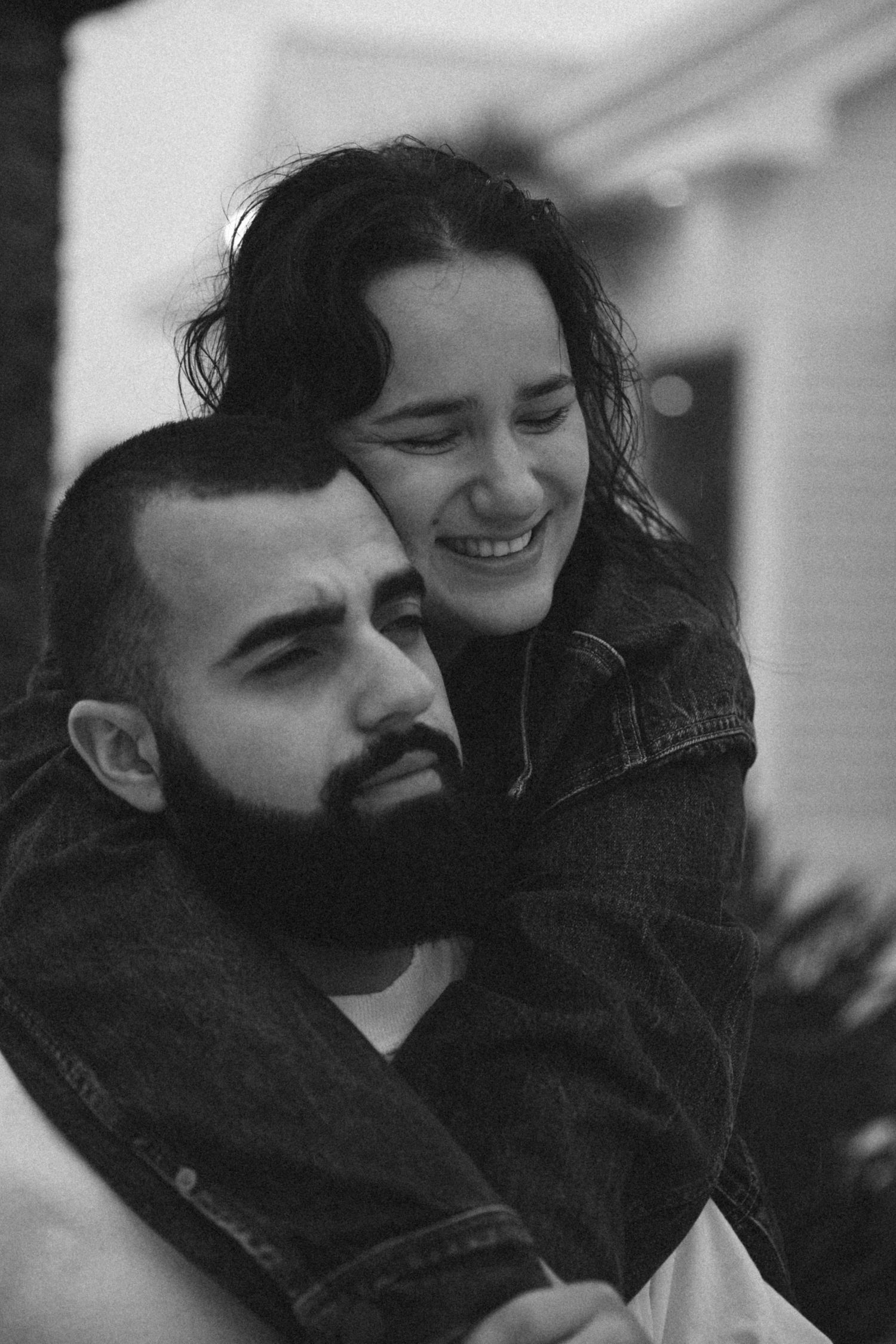 An intimate black and white portrait of a couple sharing a close moment.