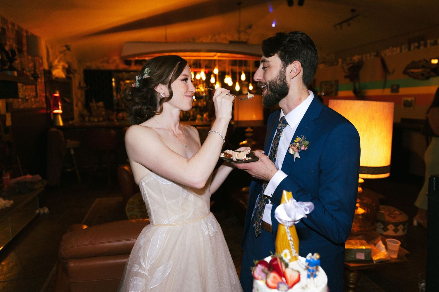 A couple sharing a romantic dance moment in an atmospheric indoor venue.