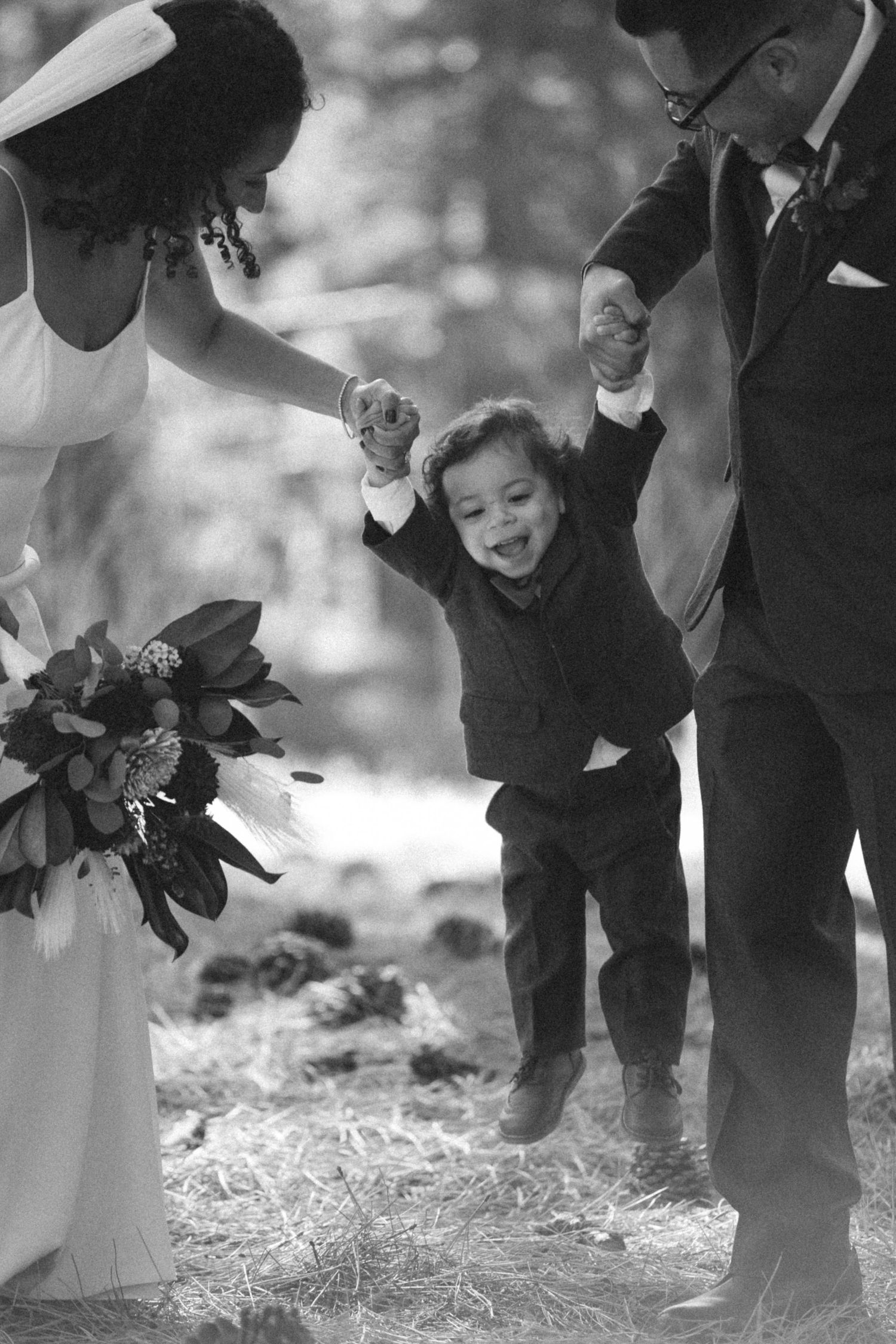 Black and white wedding photo sequence shows joyful child playing with bubbles between formal-dressed guests.
