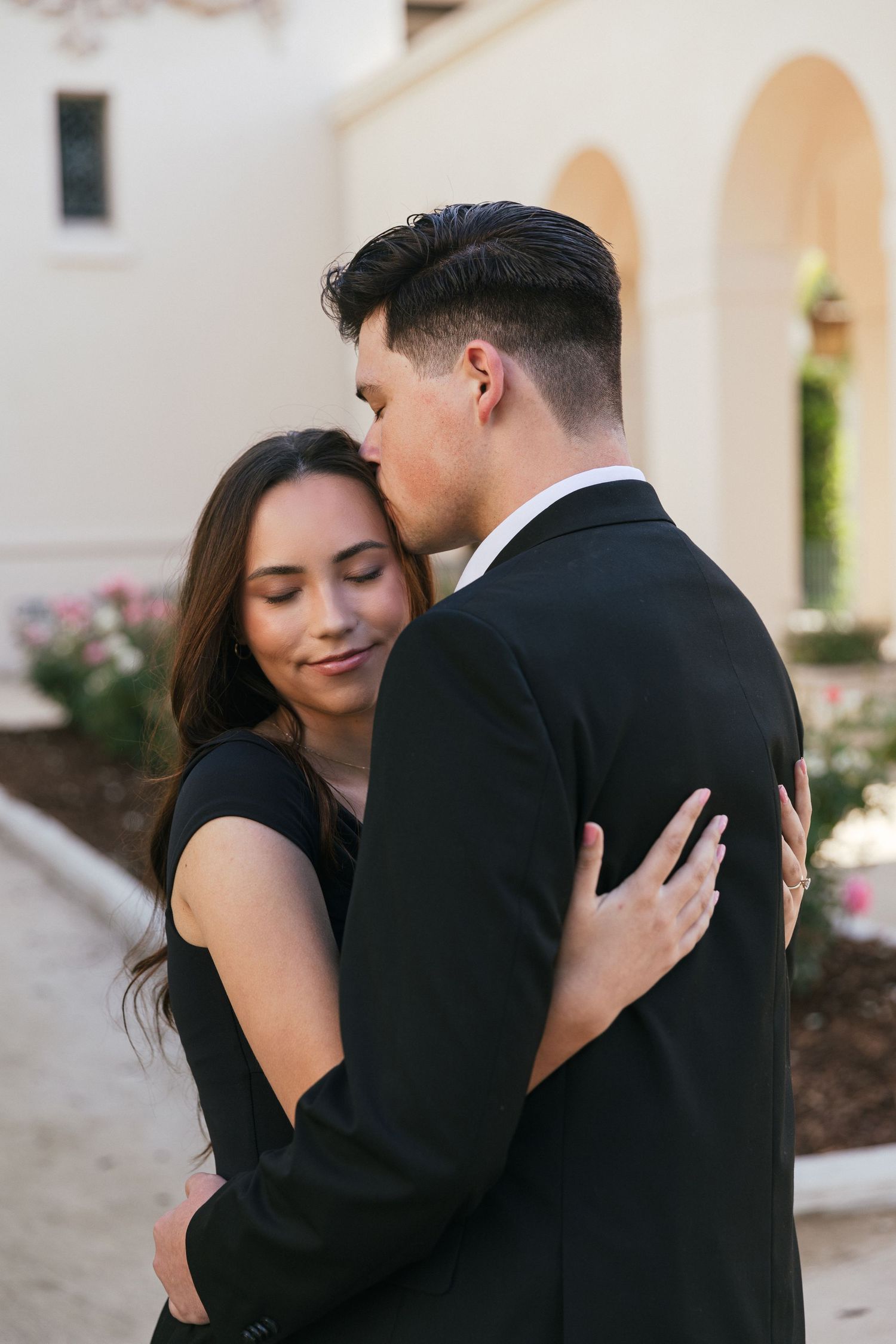 An intimate engagement session showing a couple embracing in formal attire.