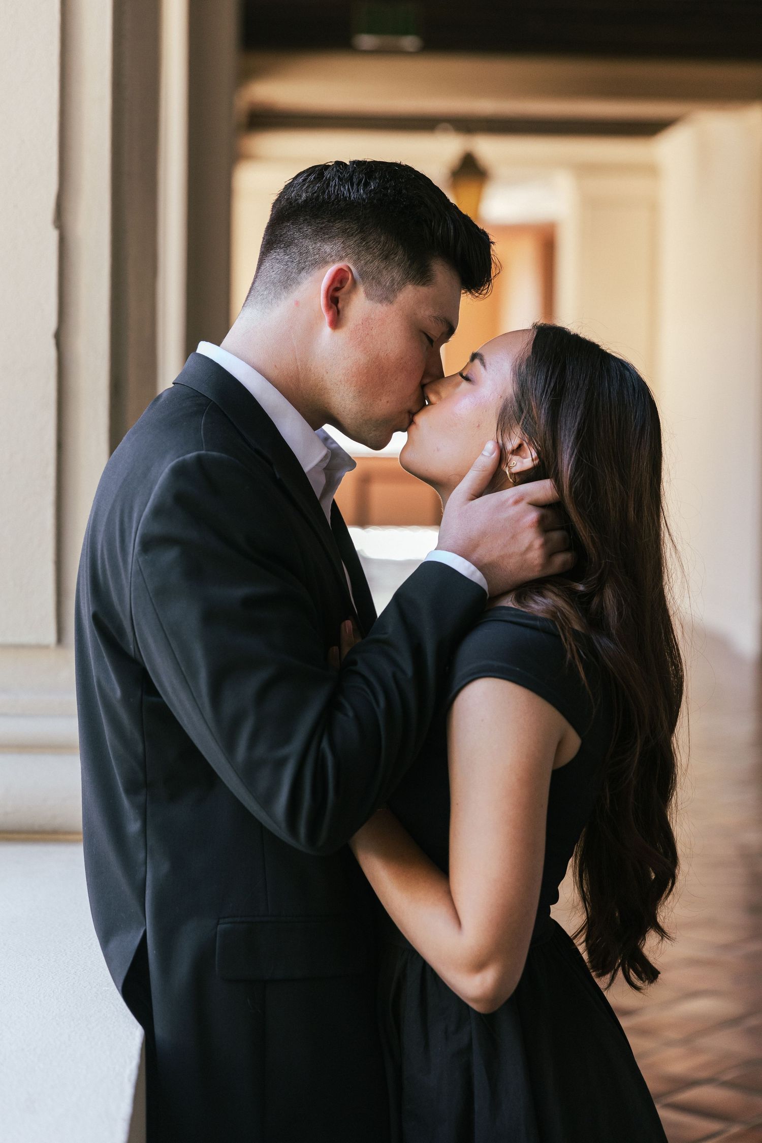 An intimate portrait of a couple sharing a passionate embrace in formal attire.