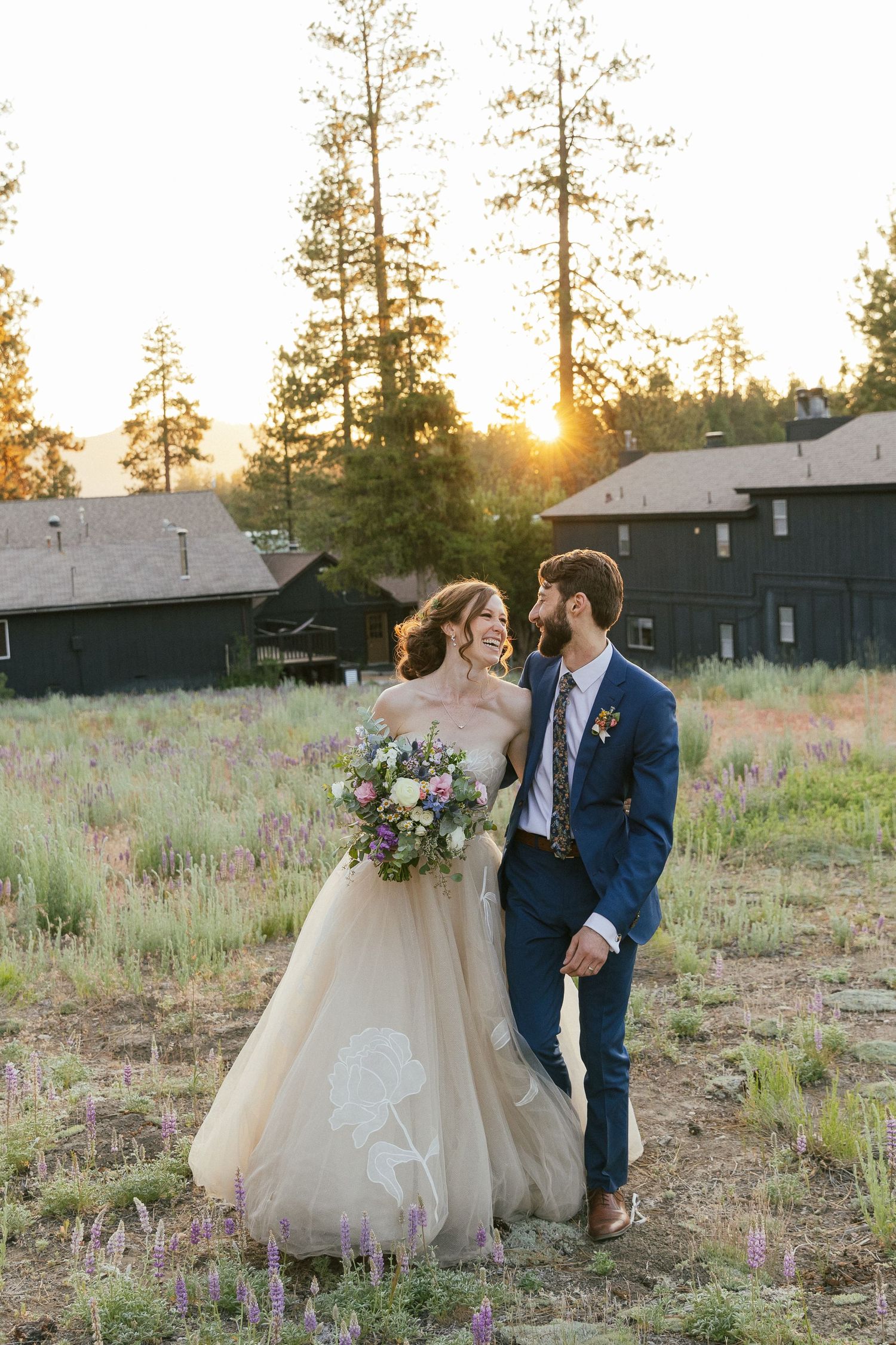 Bride and groom sharing romantic moments in rustic outdoor setting at sunset.