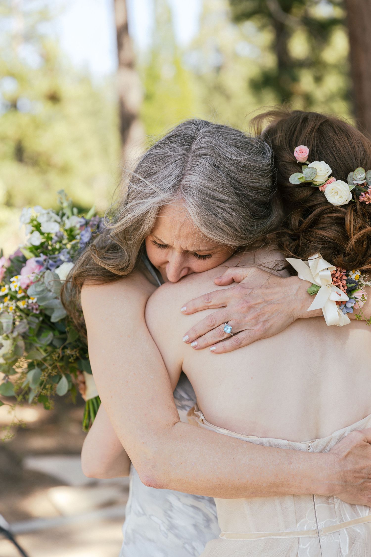 Emotional embraces captured in a series of tender moments at an outdoor wedding.