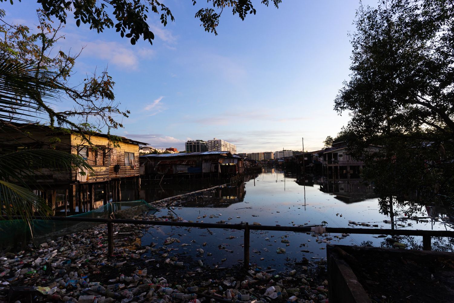 The social issue of stilt housing settlements over water involves poor waste management, leading to pollution. Kota Kinabalu, Sabah,