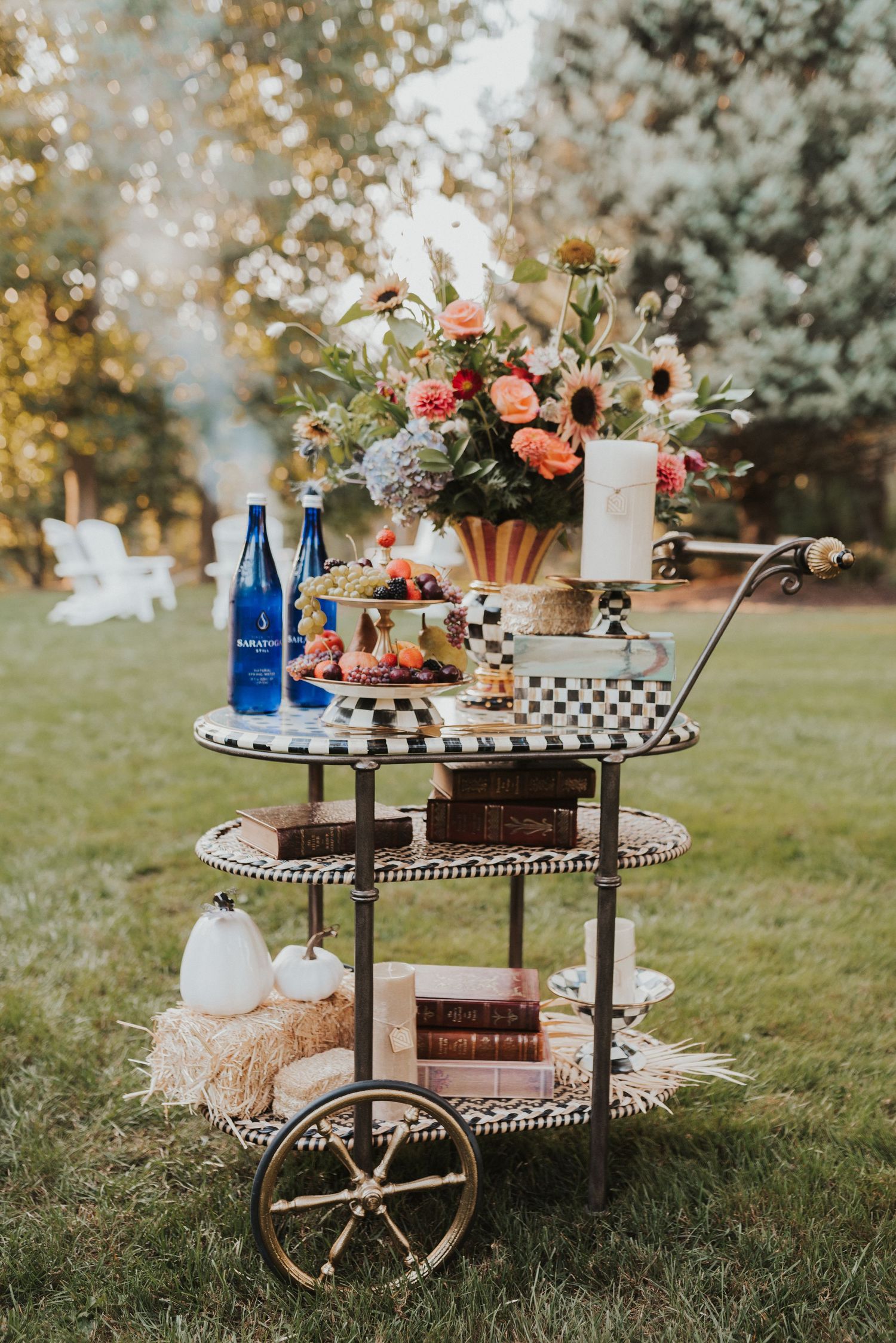 Vintage cart decorated with blue bottles, flowers and checkered accents for outdoor entertaining.