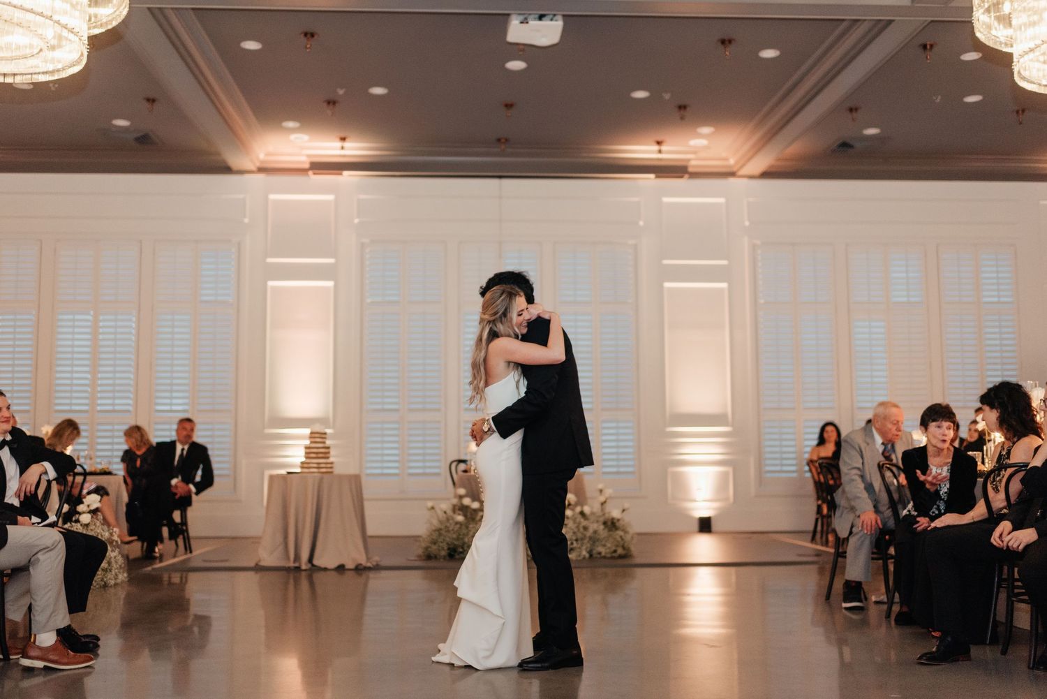Couples dancing together in an elegant white ballroom during a formal evening celebration.
