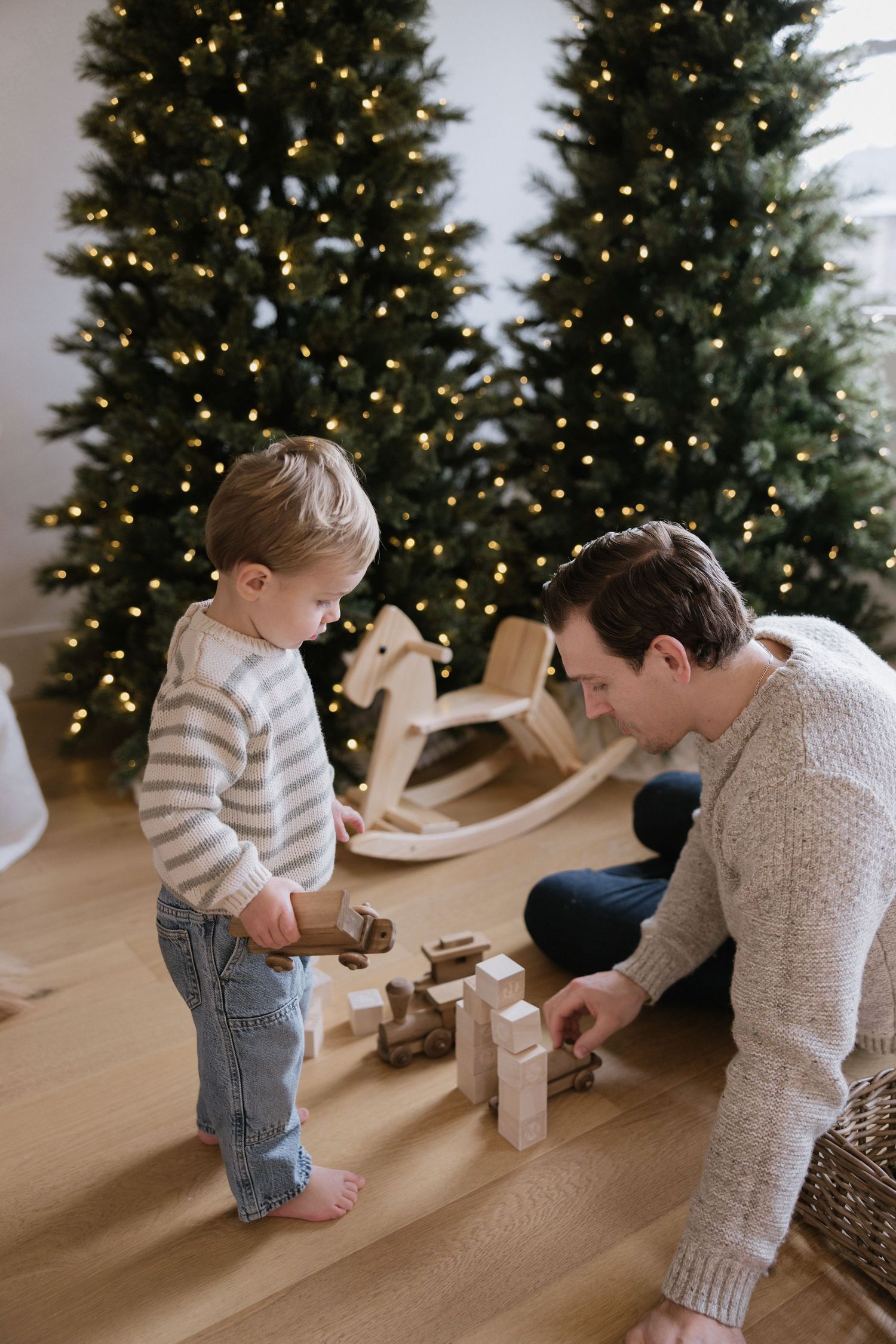 A series of candid photos showing a child and adult playing together in front of a decorated Christmas tree.