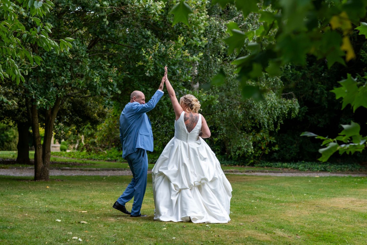 A couple dances together on a lush green lawn during a summer celebration.