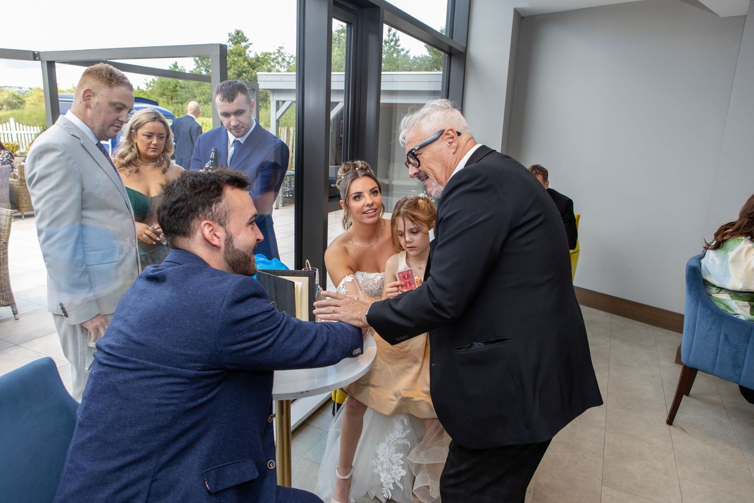 Wedding party celebrates and dances together in a reception venue with multiple candid shots of joyful moments.