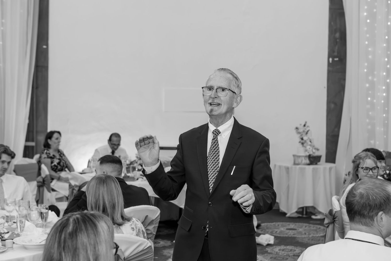 Wedding reception speeches and toasts captured in elegant indoor venue.