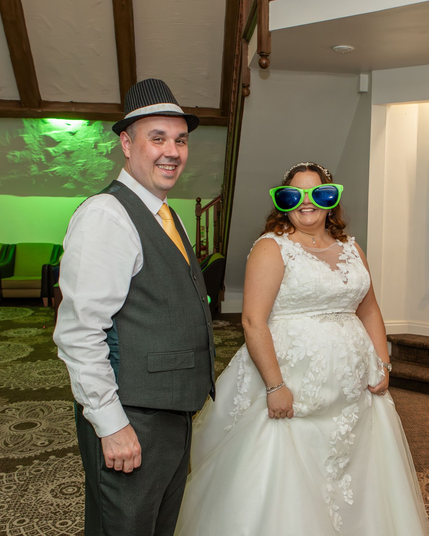 Fun wedding reception moments with couple wearing party accessories and dancing.