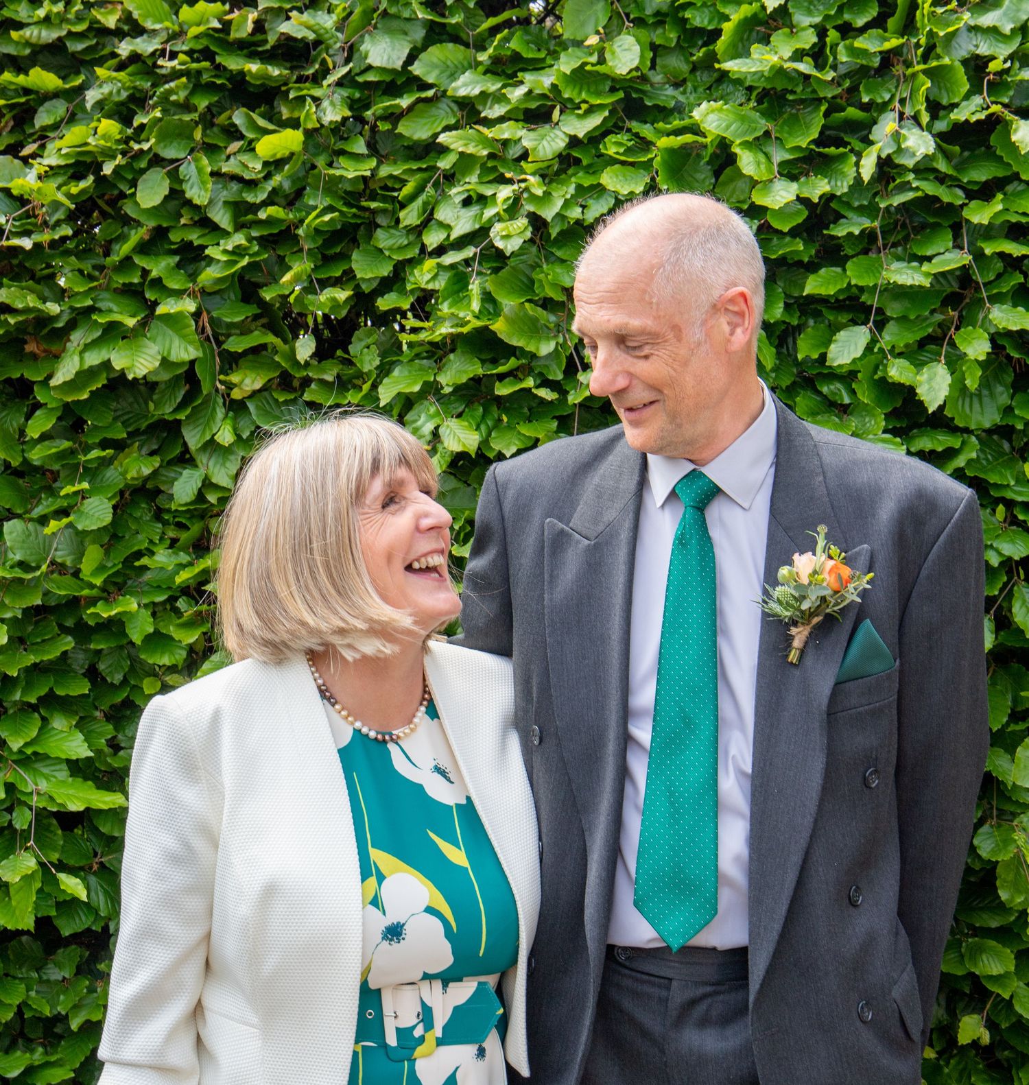 Formal group portrait against ivy wall with matching emerald green accents.