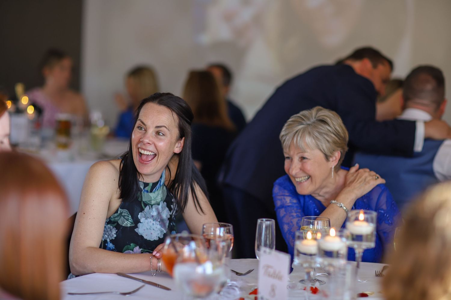 Guests laughing and enjoying themselves at a social gathering.