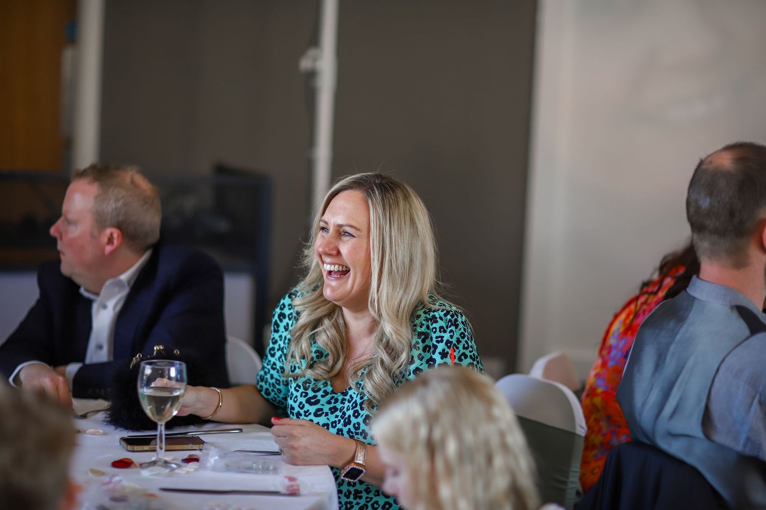 Guests engaged in lively conversation at a formal dining event.