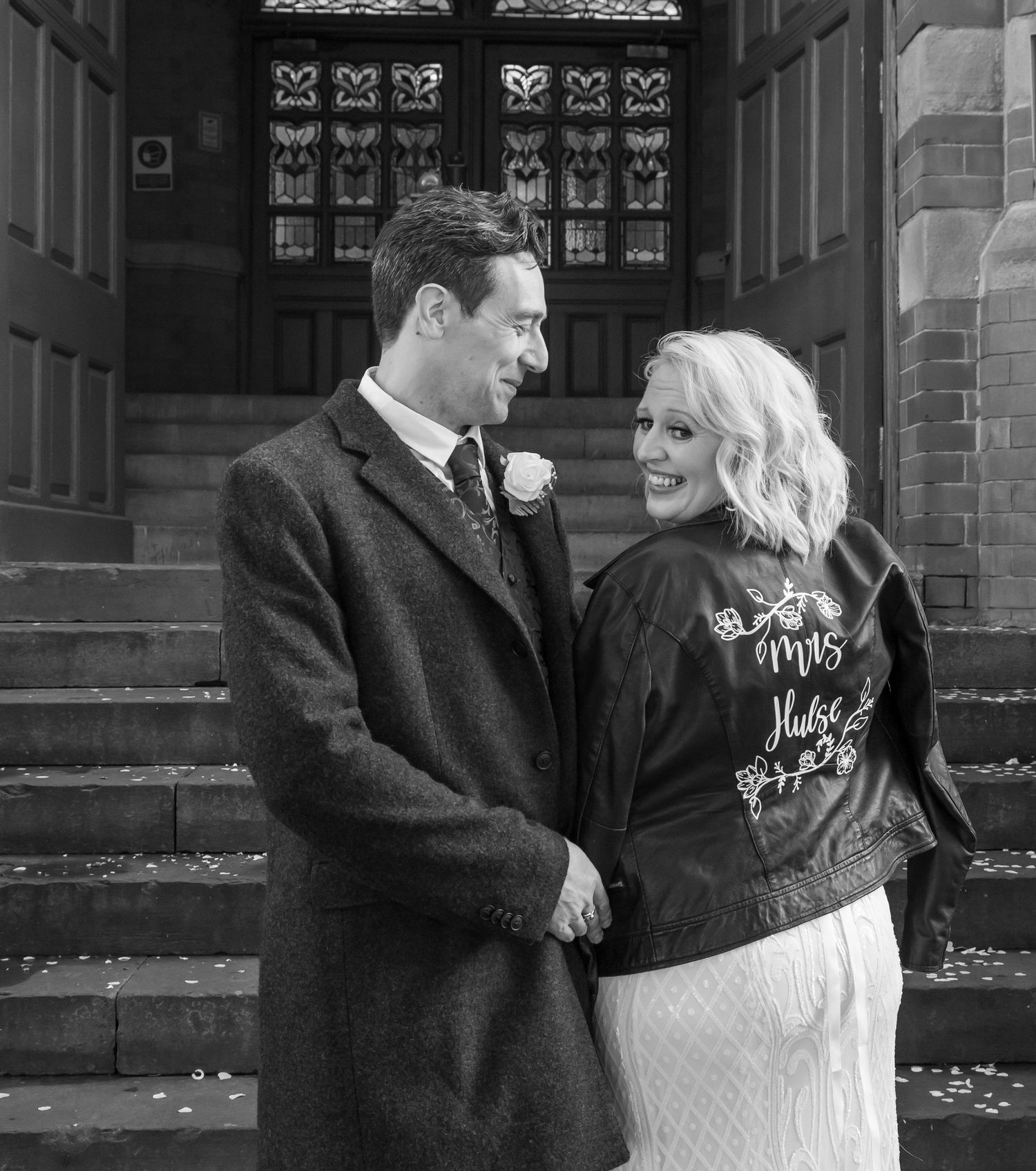 Black and white wedding portraits showing tender moments on church entrance steps.