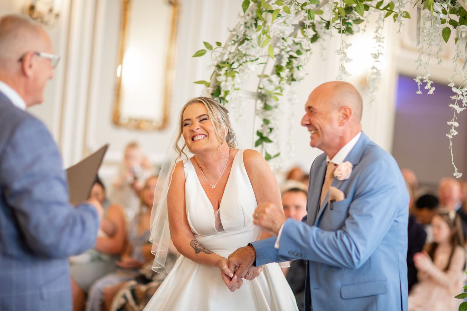 Wedding couple sharing a tender moment during their first dance under elegant floral decorations.