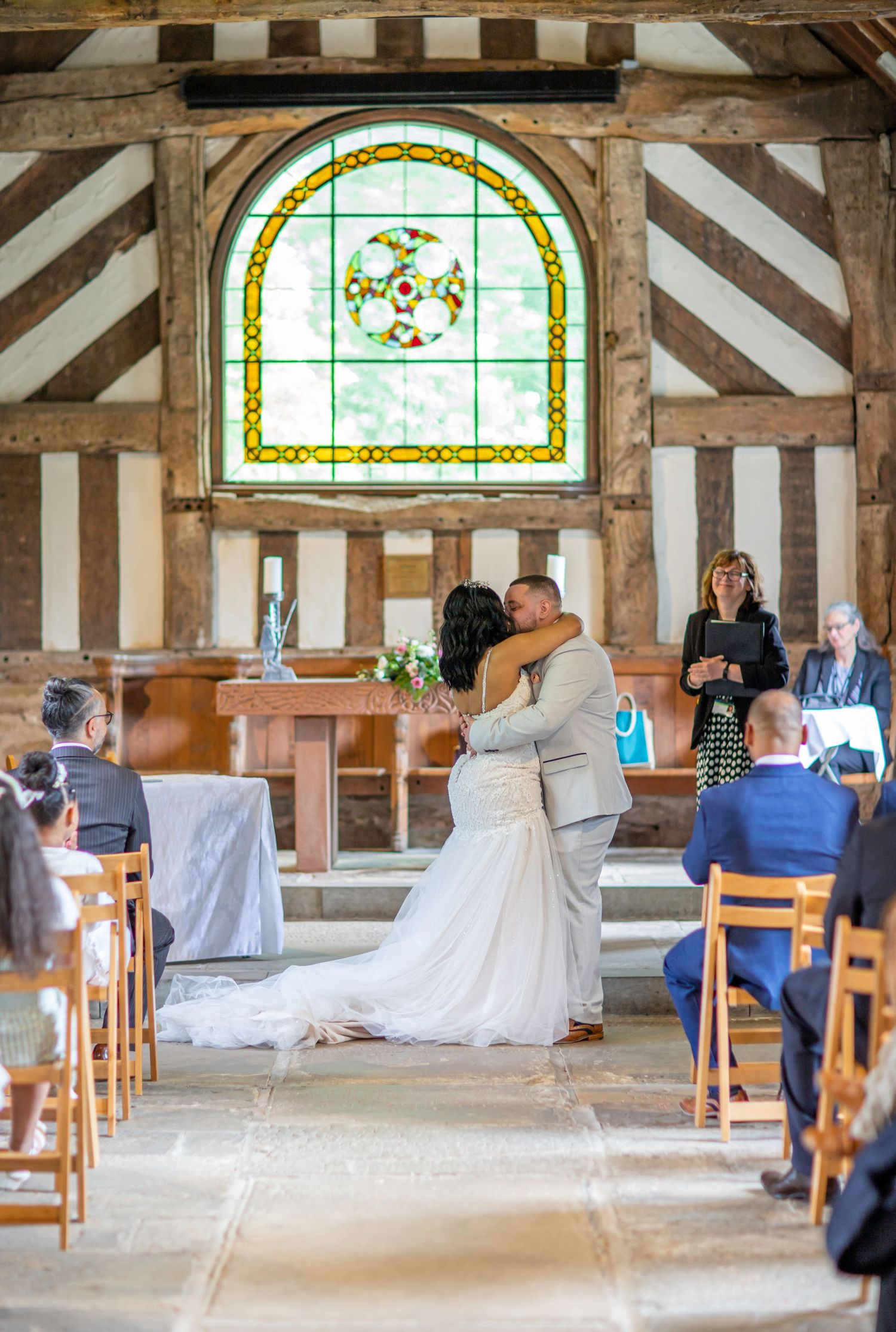 Historic timber-framed venue with stained glass windows and wedding ceremony setup.