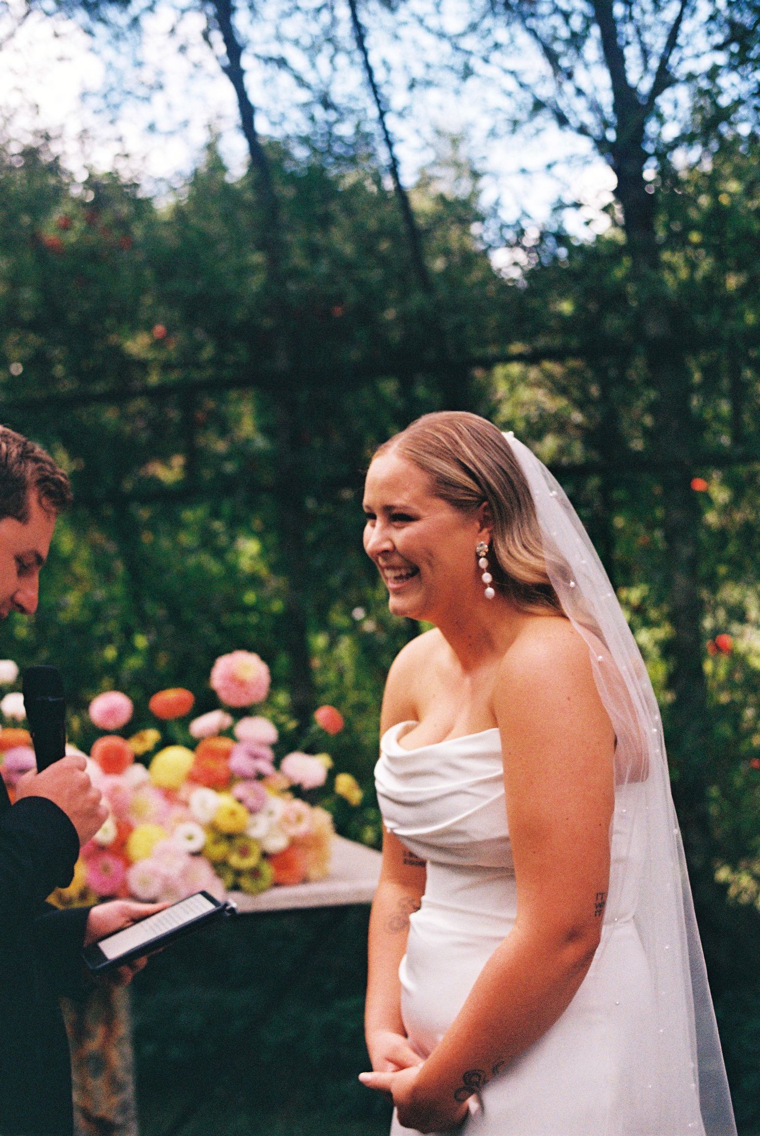Film photo of bride laughing during ceremony at TreeChurch and Gardens