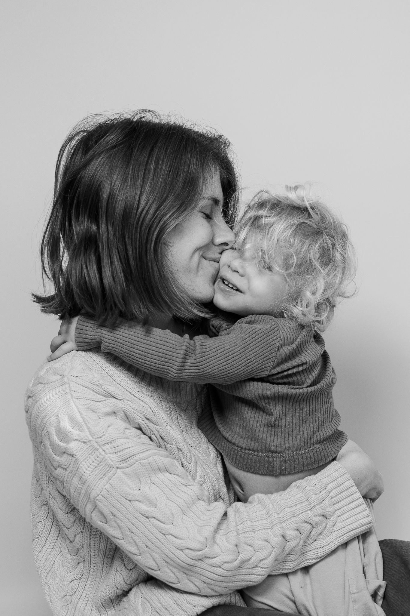 Intimate black and white portrait showing loving embrace between parent and child.