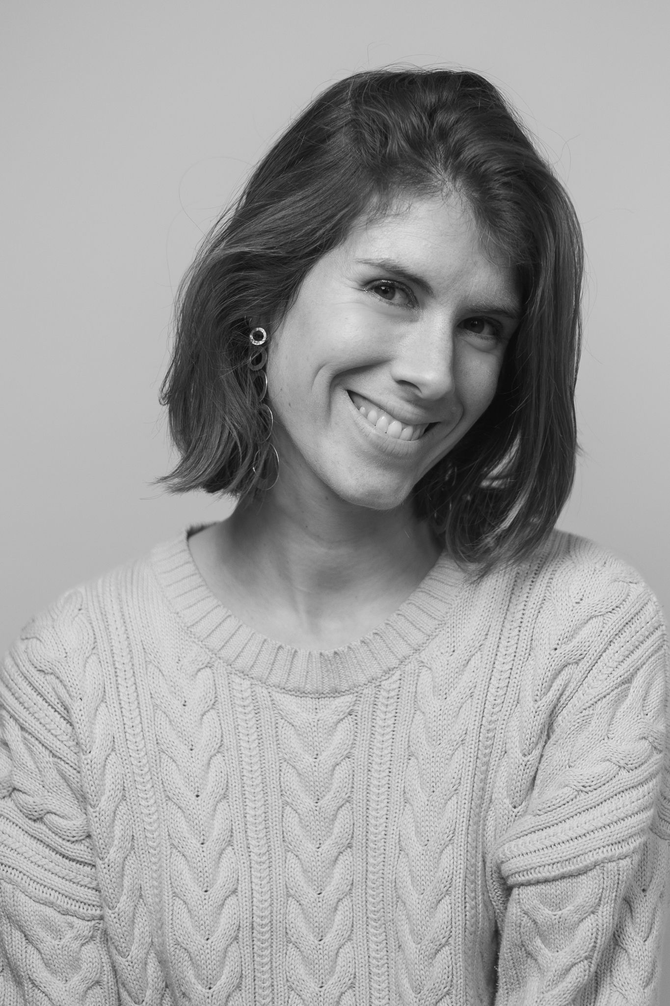 Candid portrait showing joyful expression while wearing cozy cable knit sweater.