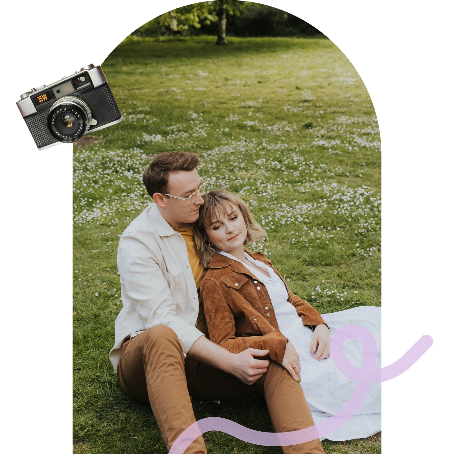 Couple relaxing on grass with white spring flowers and vintage camera decoration.