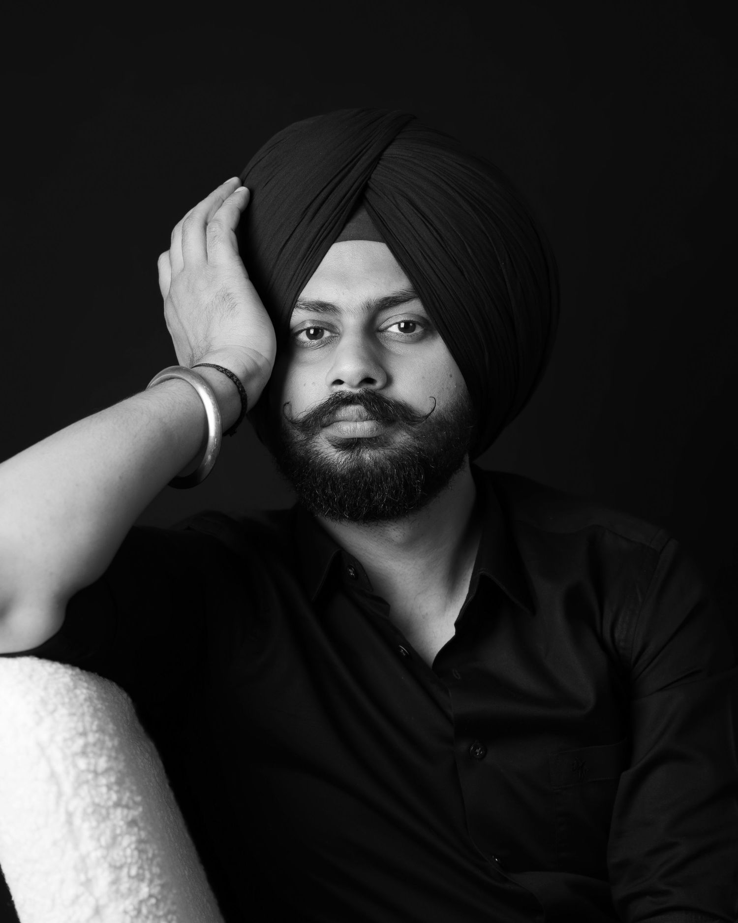 Black and white portrait series showing a person in a turban against dark backgrounds.