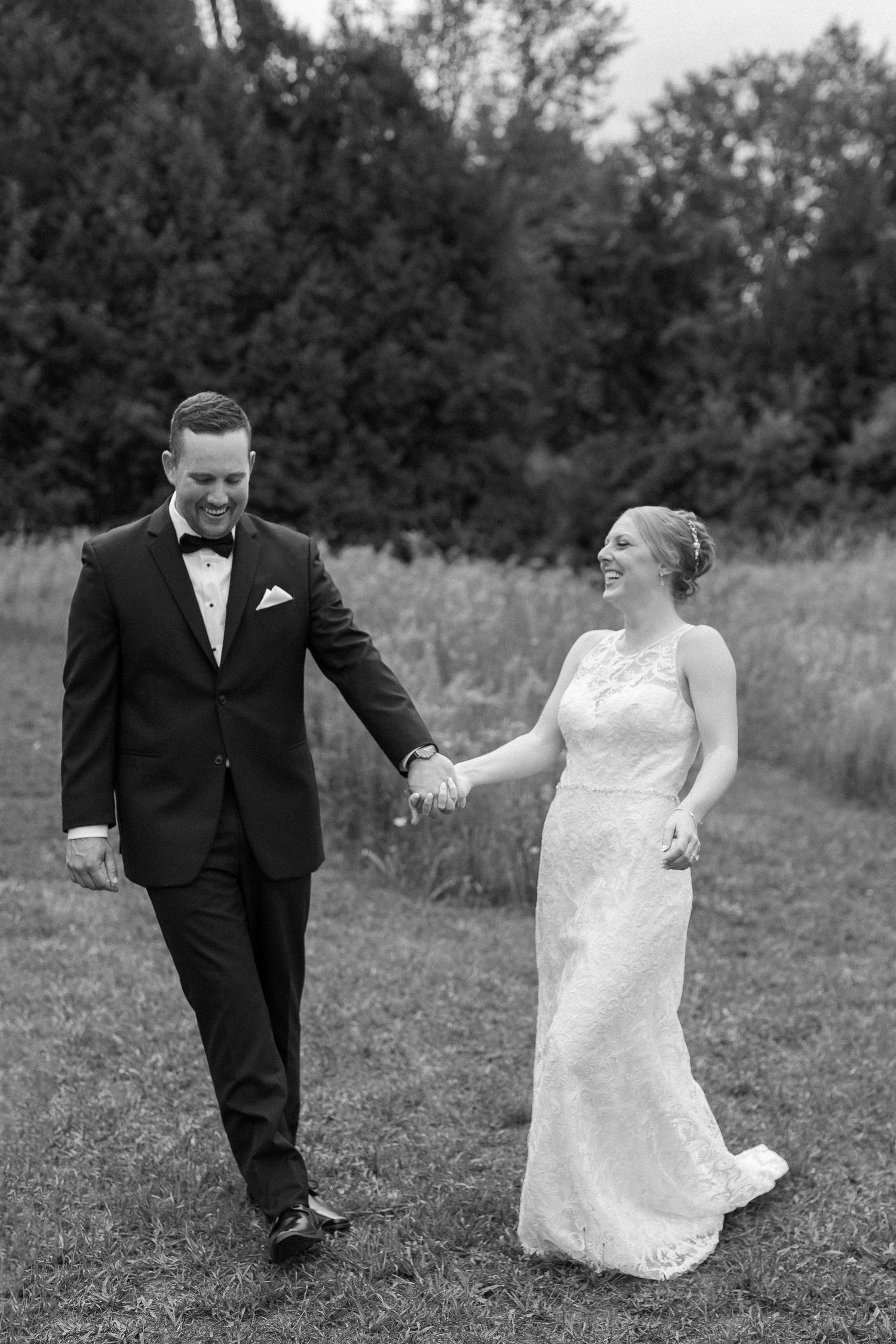 Black and white wedding sequence showing playful moments between couple in a field.