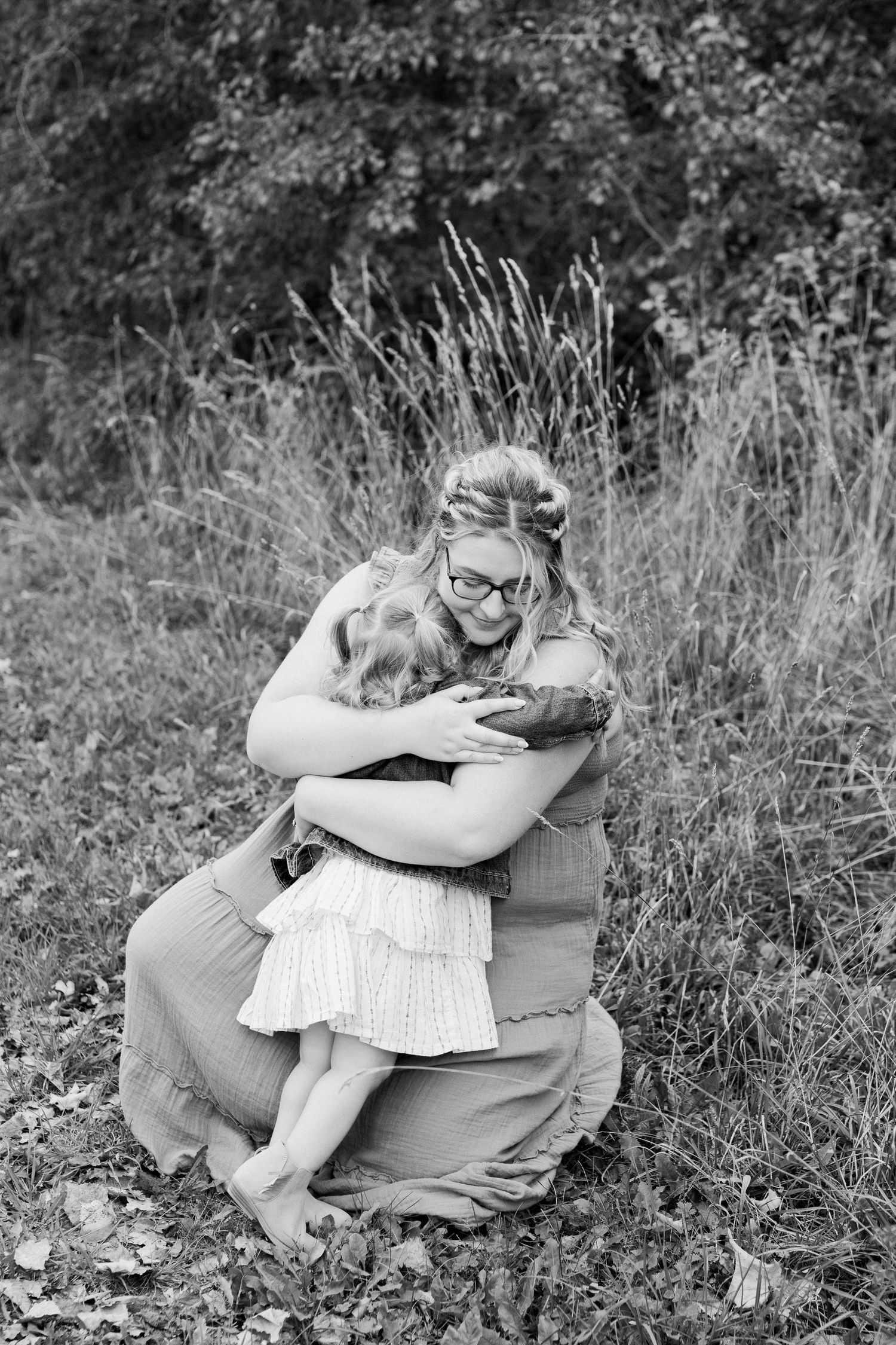 Black and white series of intimate family embraces in outdoor setting.