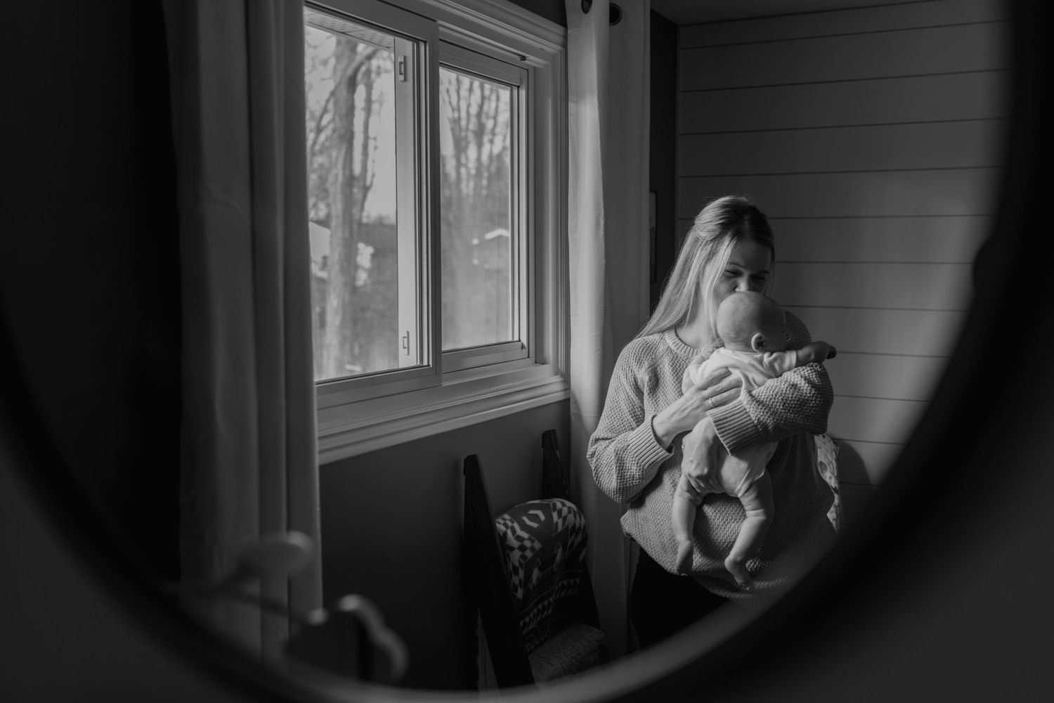 Newborn nestled in mother's arms in Guelph, Ontario. Lifestyle session captured by Katie Crane Photography.