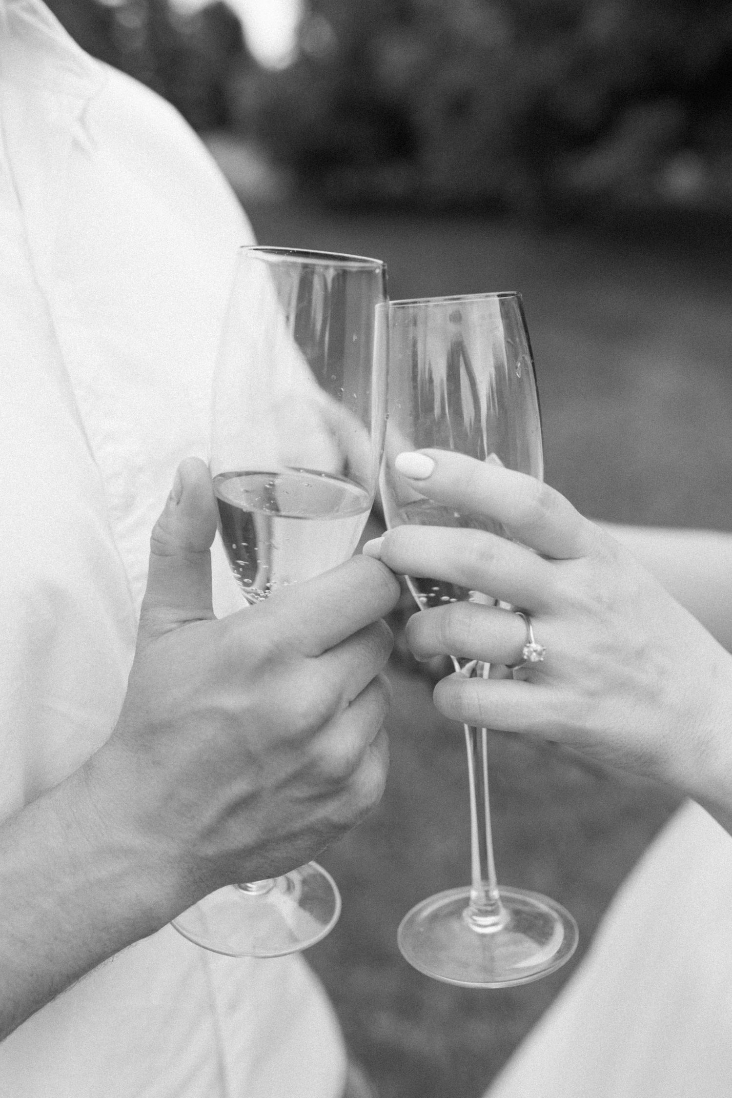 Engagement session in Georgina, Ontario: Couple cheering their champagne glasses together - Katie Crane, Candid Wedding 