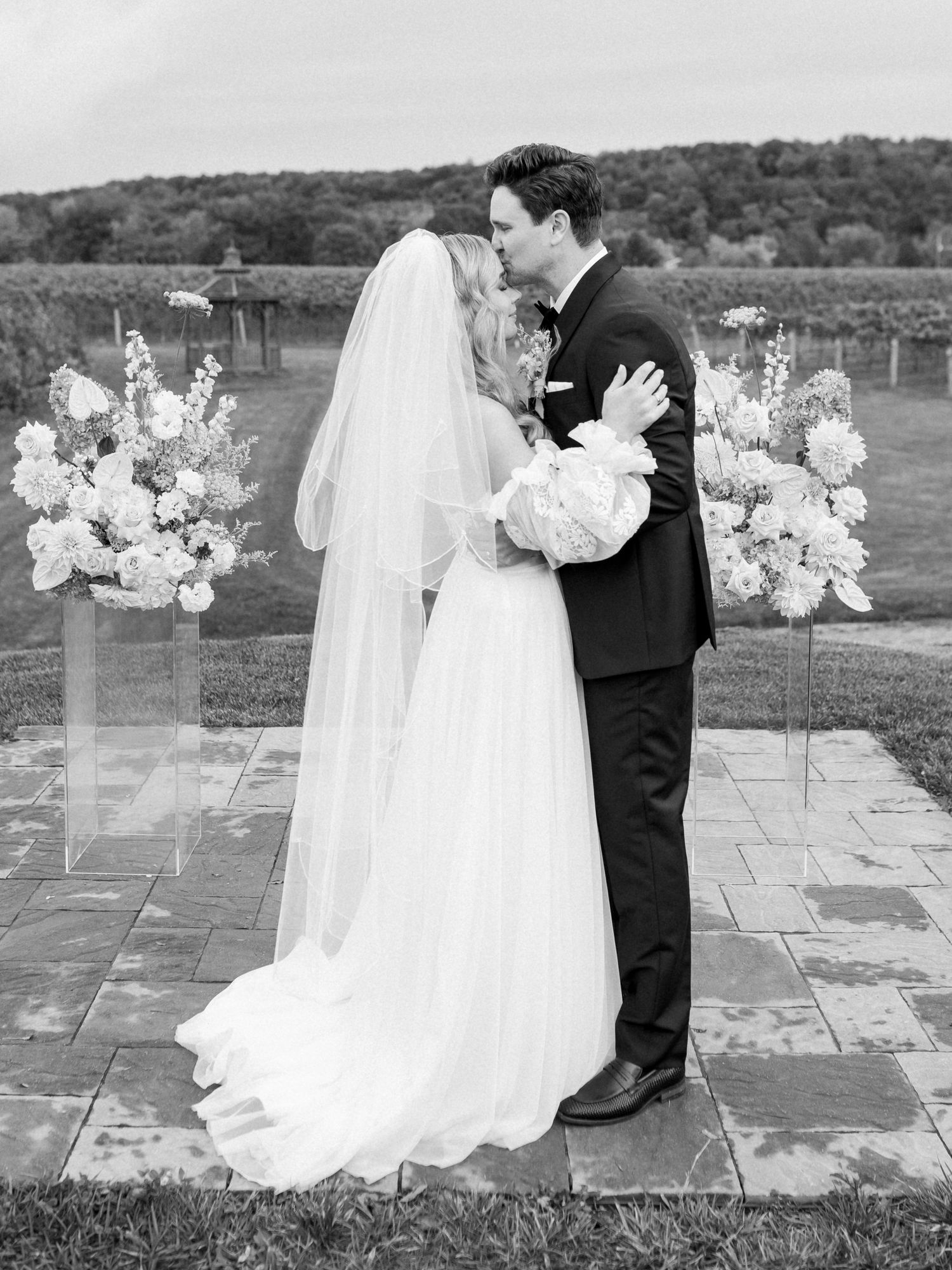 The groom holds his bride at the alter at the end of the ceremony kissing her on the forehead sweetly in Cave Springs, O