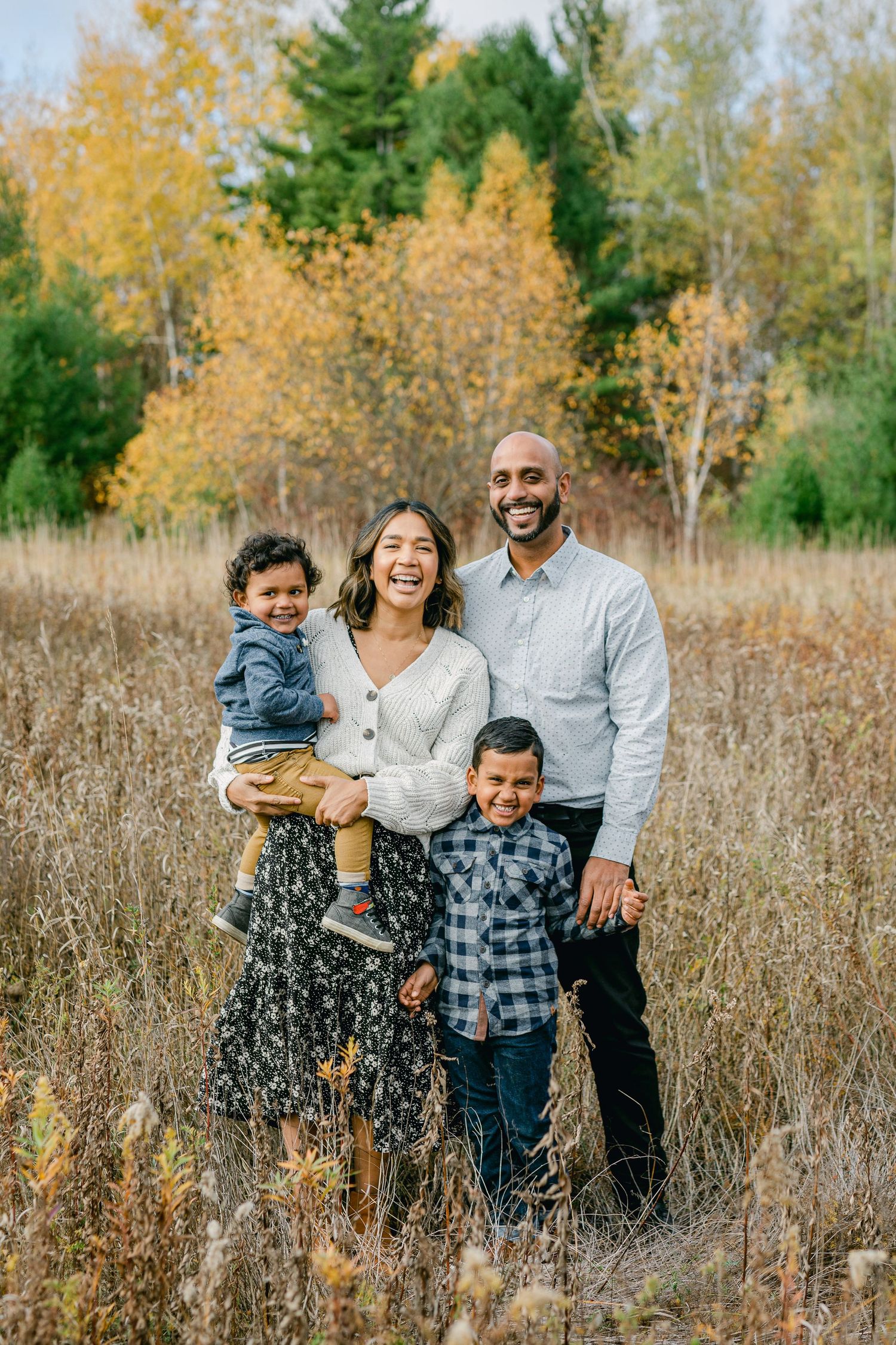 Family portrait session in fall field with natural golden light.