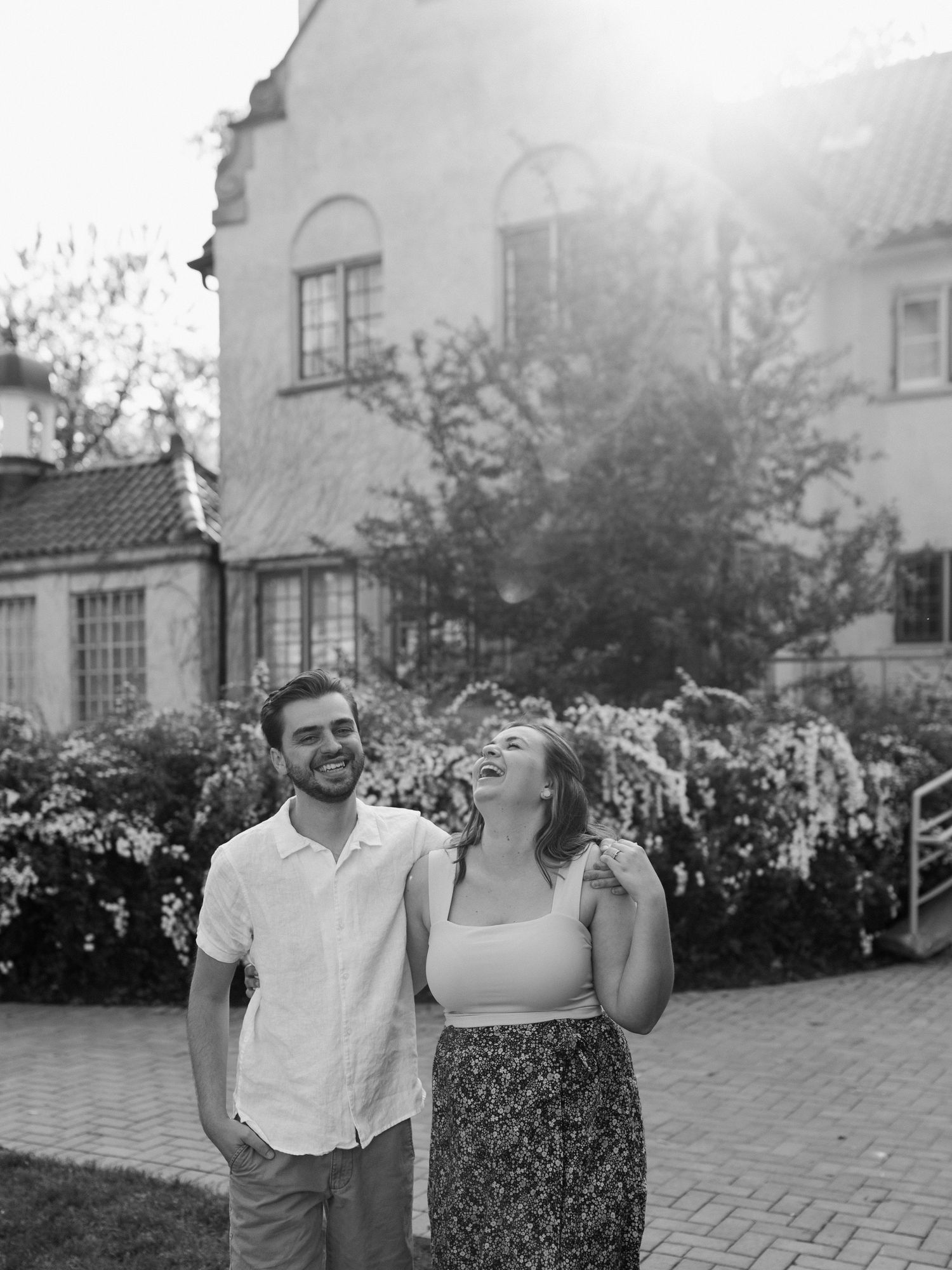 A couple shares a lighthearted moment together outside a historic building.
